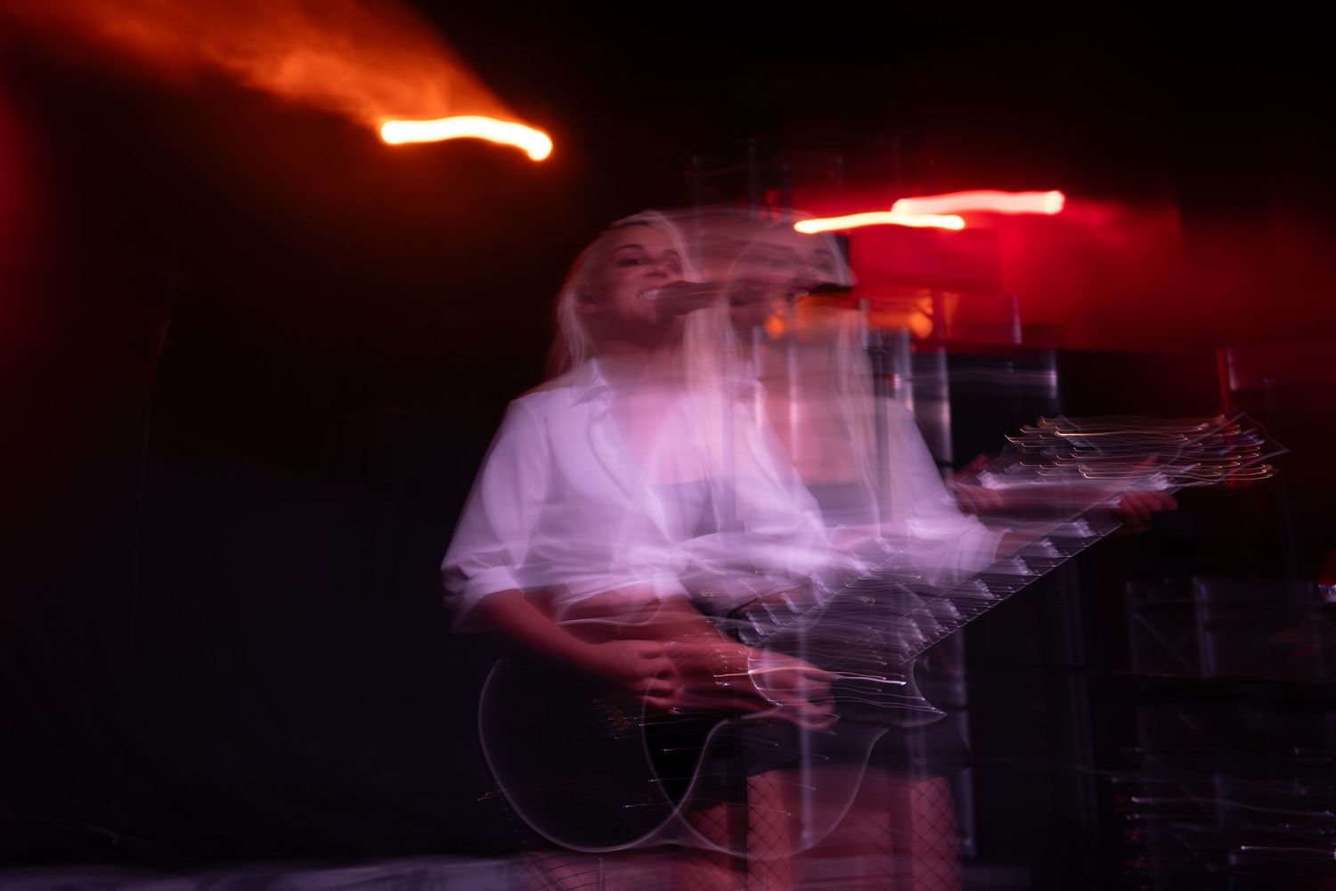 Motion blur of red stage lights creating abstract patterns during a concert performance.