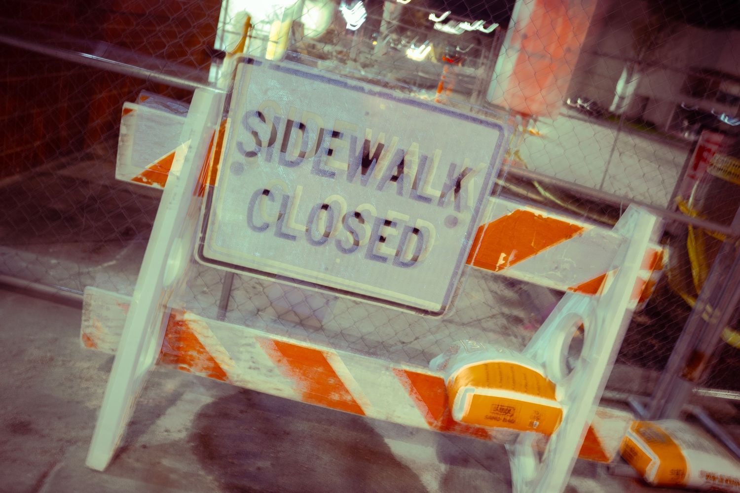 Street signs and barriers visible through a blurred nighttime exposure.