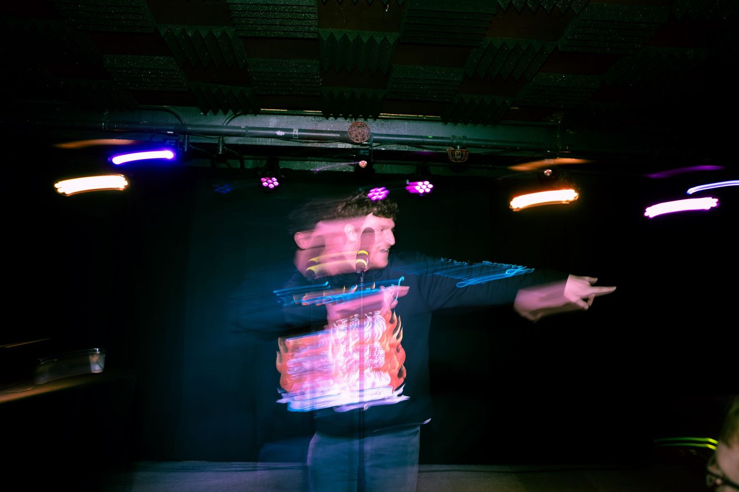 Abstract light painting effect creating pink and blue streaks against dark background.