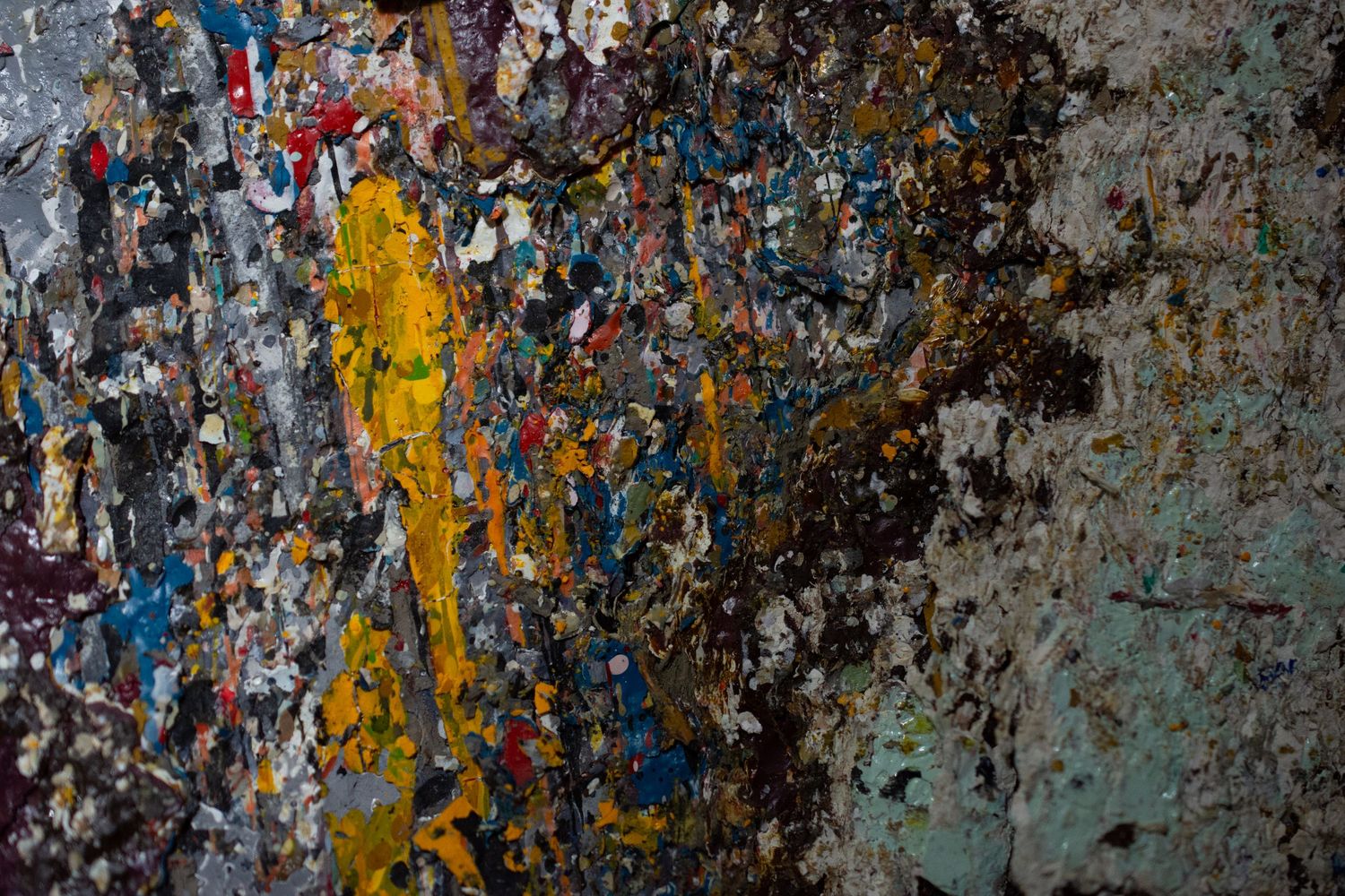 Abstract textured background with peeling paint in blue, yellow and black tones.