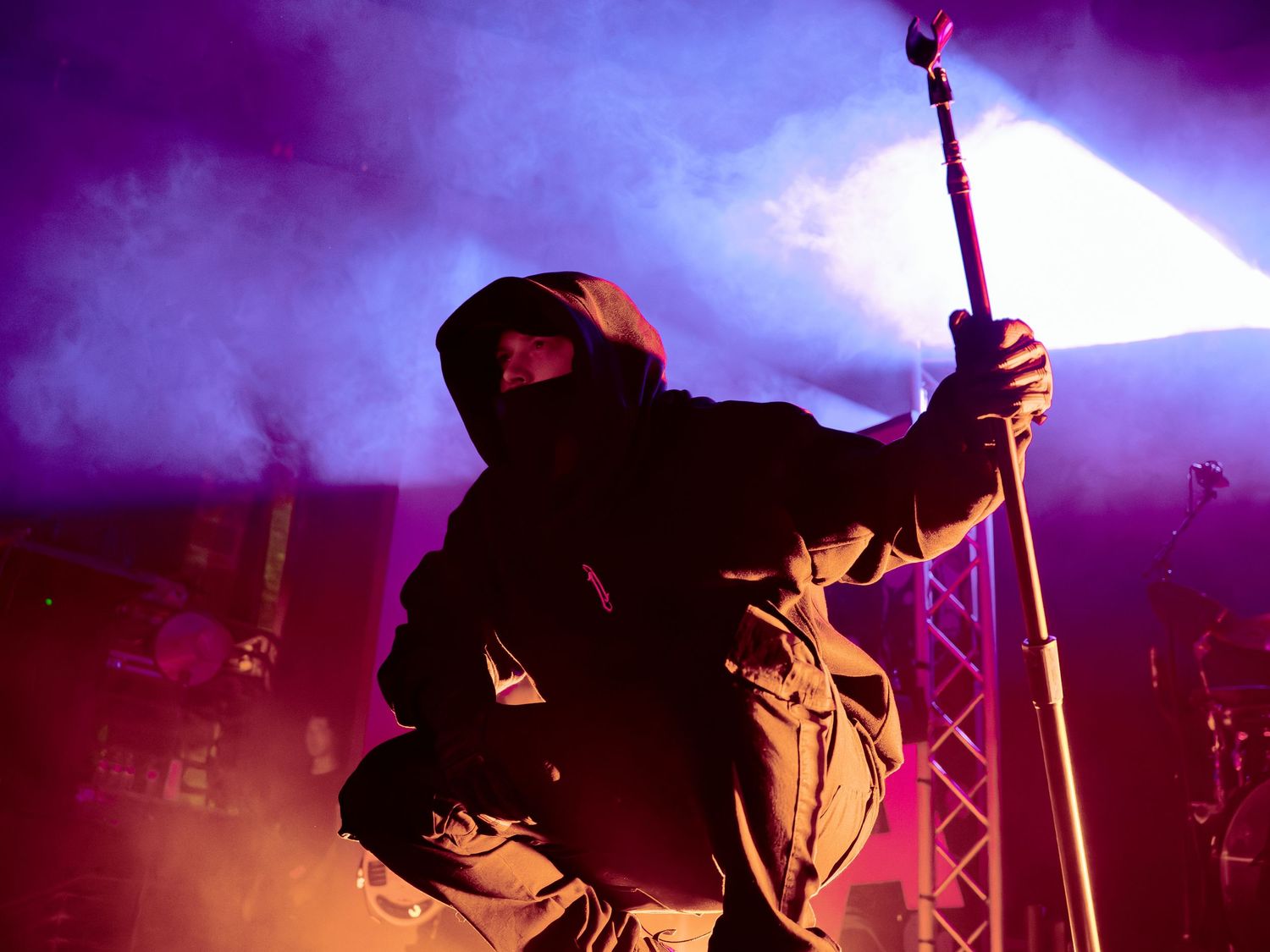 Dramatic purple stage lighting creates silhouettes of performers during a live show.