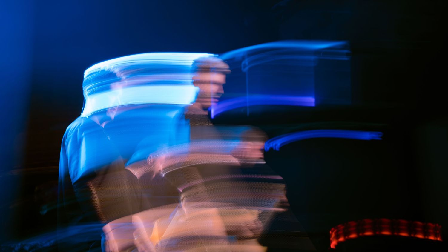 Electric blue light streaks forming waves against black background.