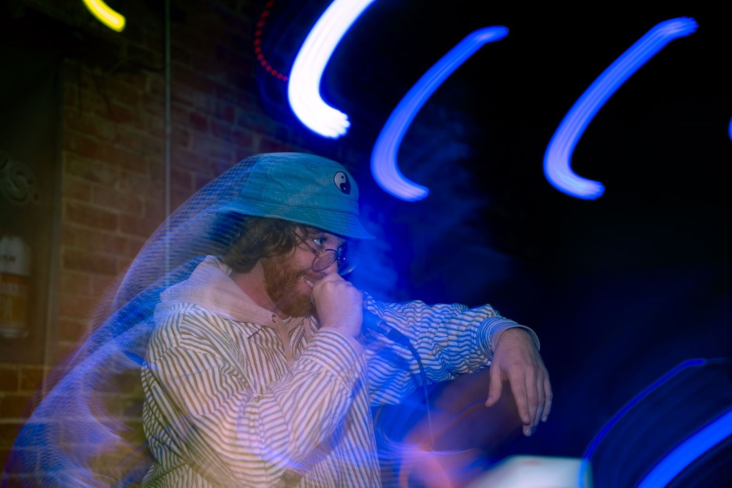 Artist performing under blue neon lights with motion blur creating dreamy atmosphere.