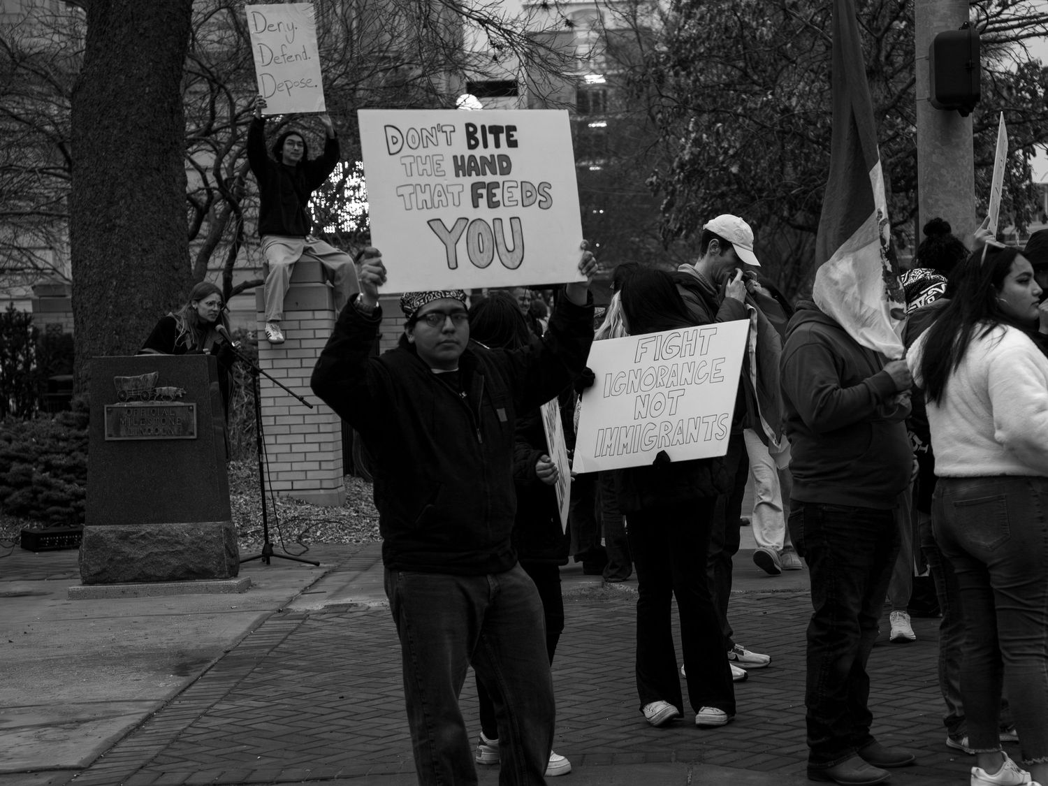 People holding protest signs stand together during a public demonstration.