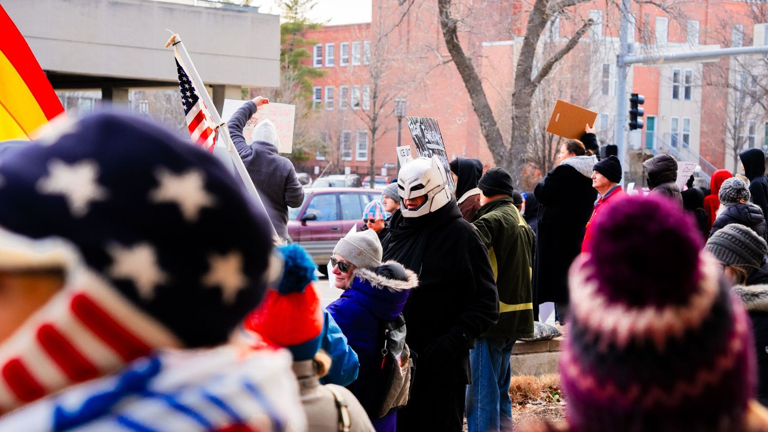 Crowd of protesters gathered with American flags and winter hats.