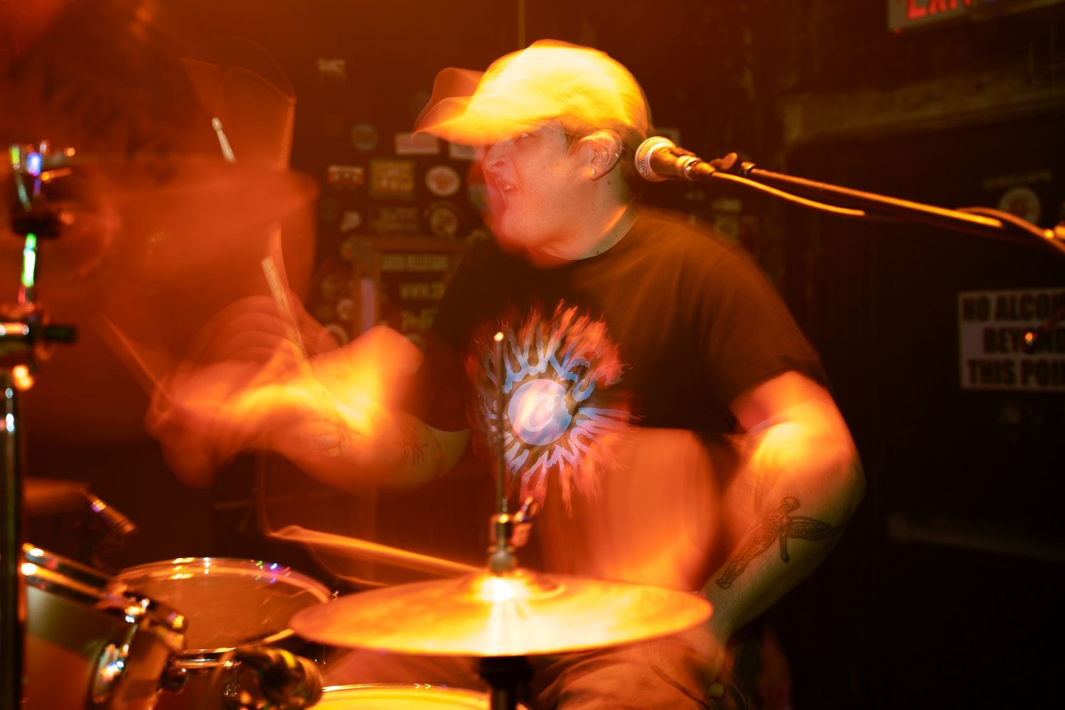 Warm stage lights illuminate musicians performing in a dark concert venue with glowing effects.