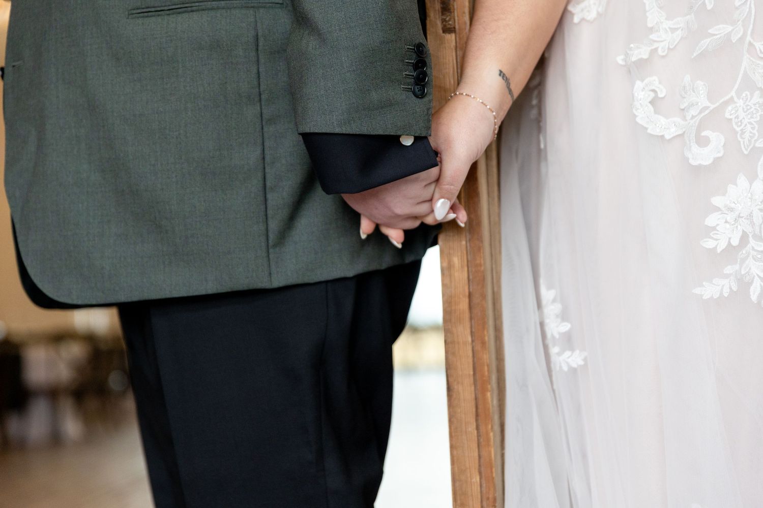 Detail shot of formal wedding attire with white lace against dark fabric.