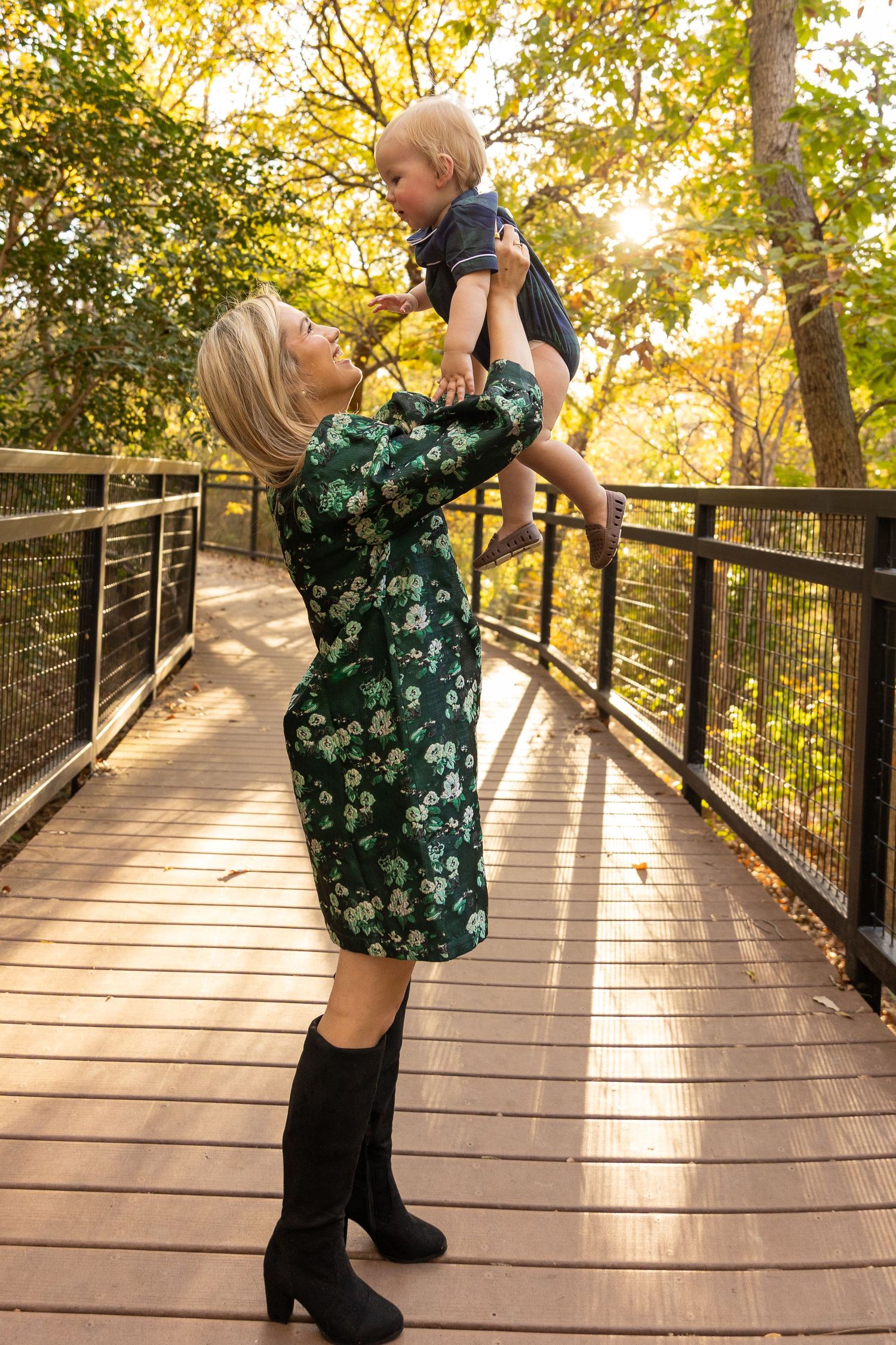 Playful moment on a wooden bridge with autumn foliage in background.