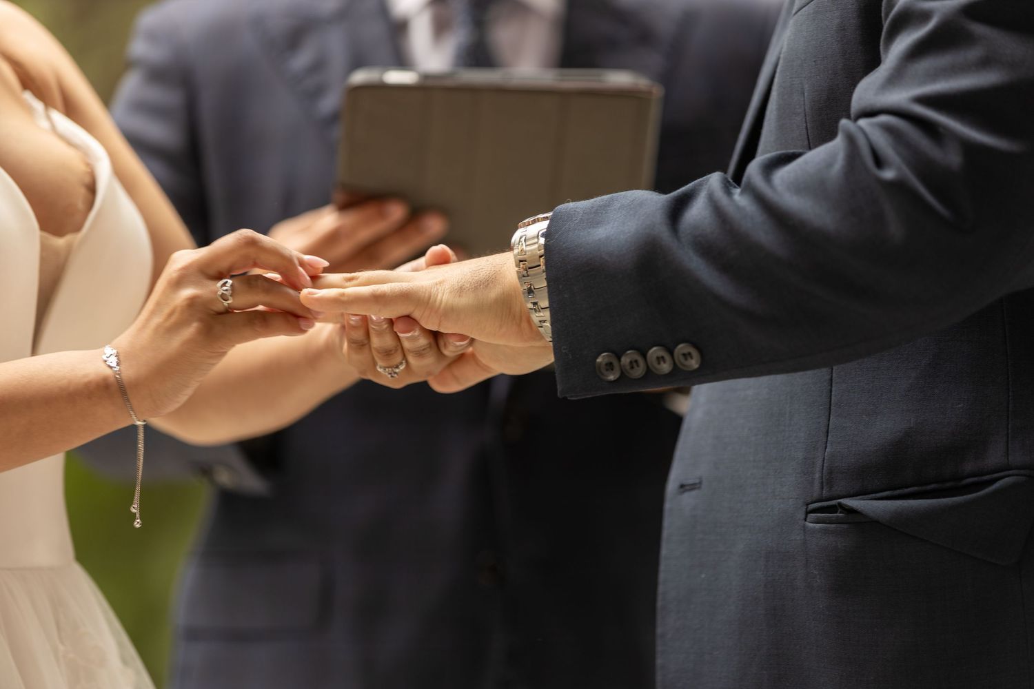 Hands exchanging wedding rings during an intimate ceremony.
