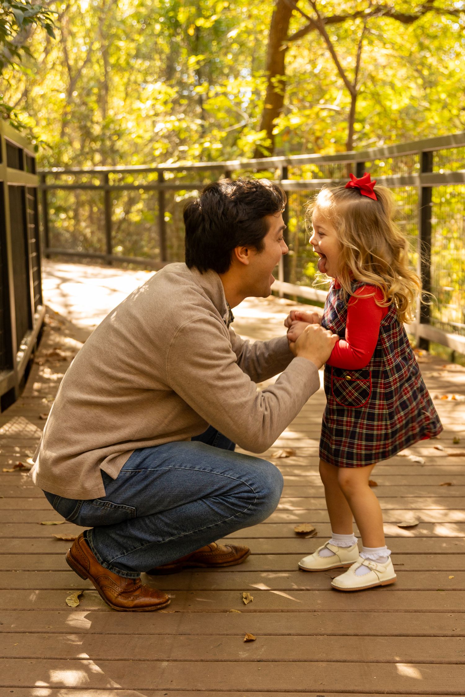 Candid family interaction on wooden deck during autumn photoshoot with golden lighting.