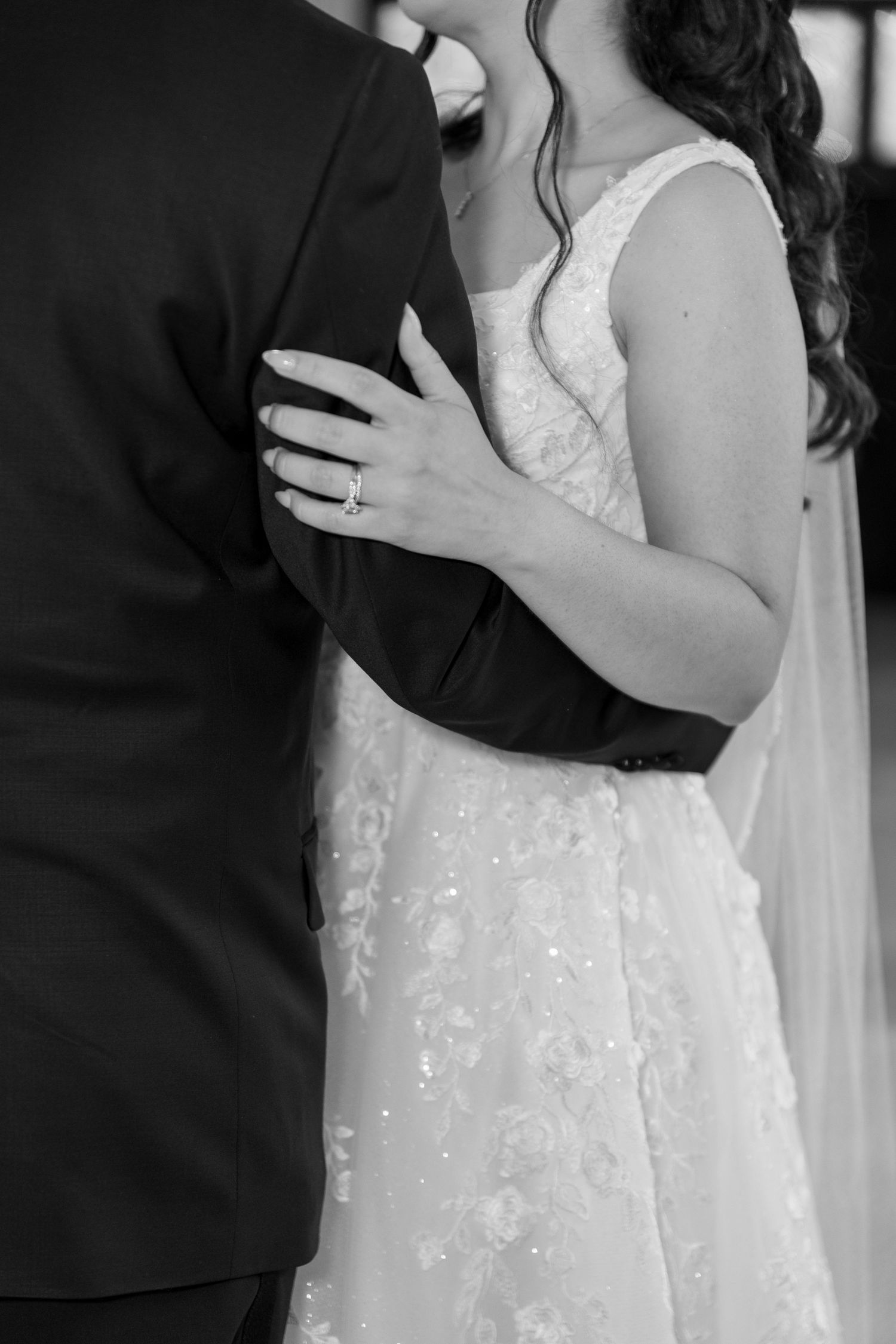 Black and white close-up shots of bride and groom embracing during wedding photoshoot.
