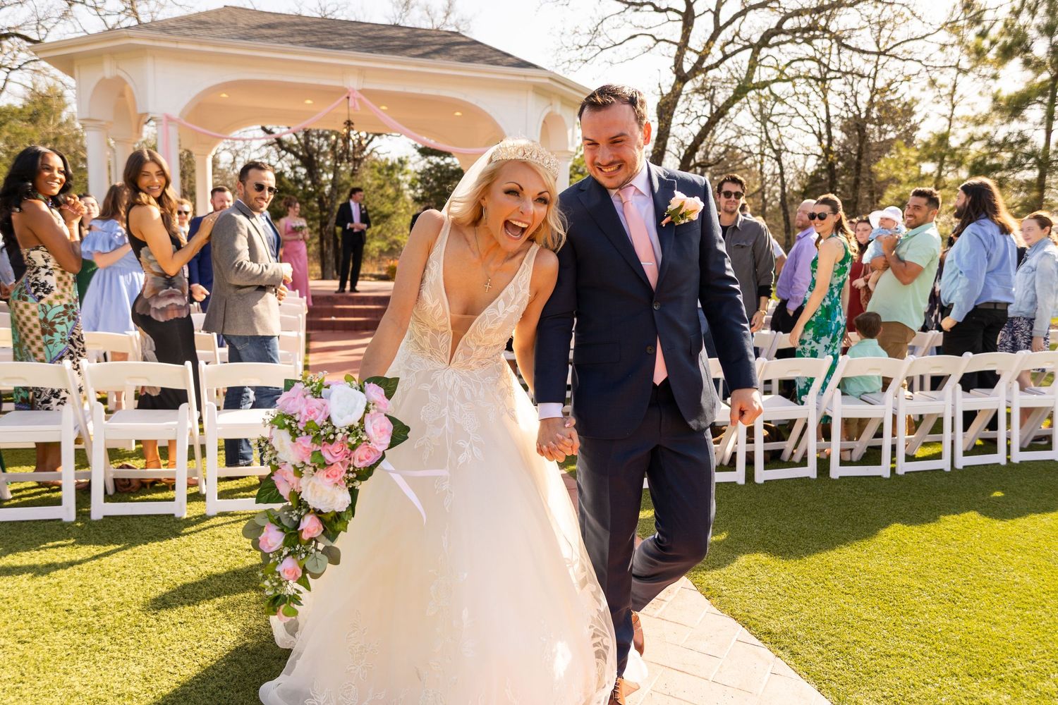 Wedding ceremony setup with white chairs on lawn in front of elegant venue.