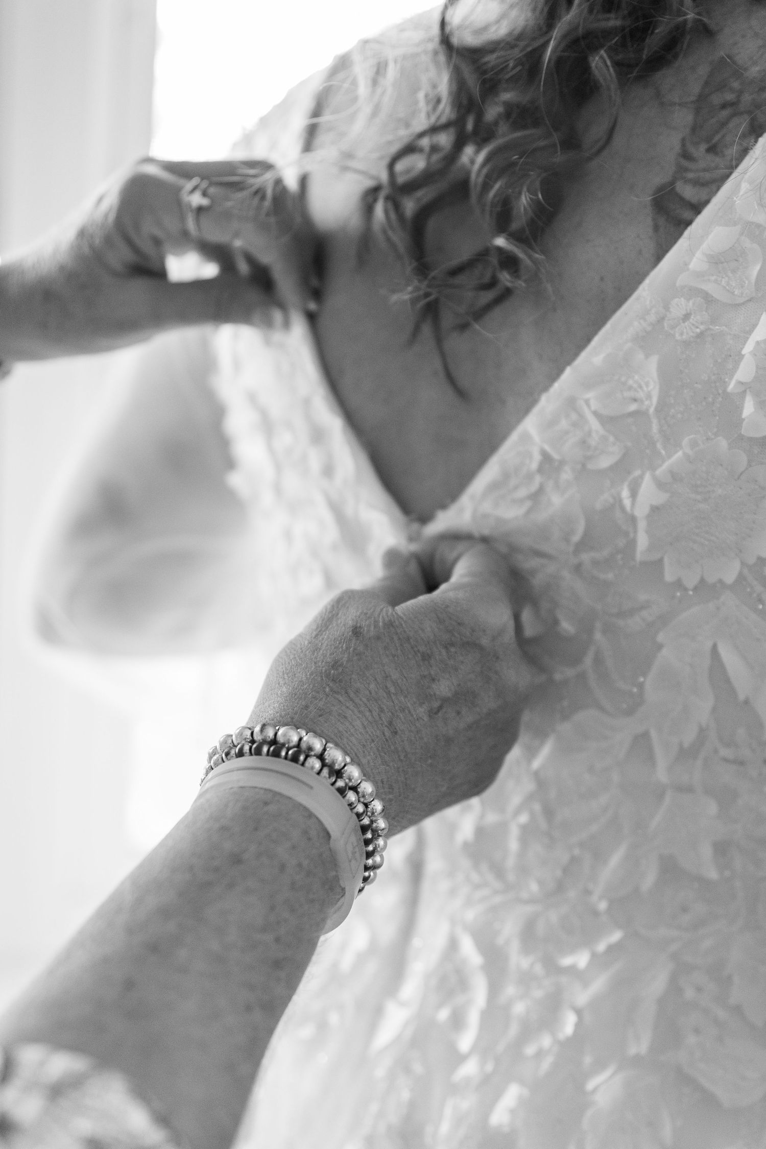 Close-up detail of intricate lace pattern on white wedding dress.