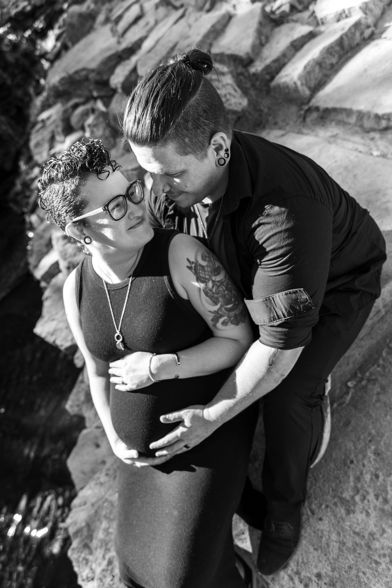 Black and white maternity photoshoot showing intimate moments between couple.