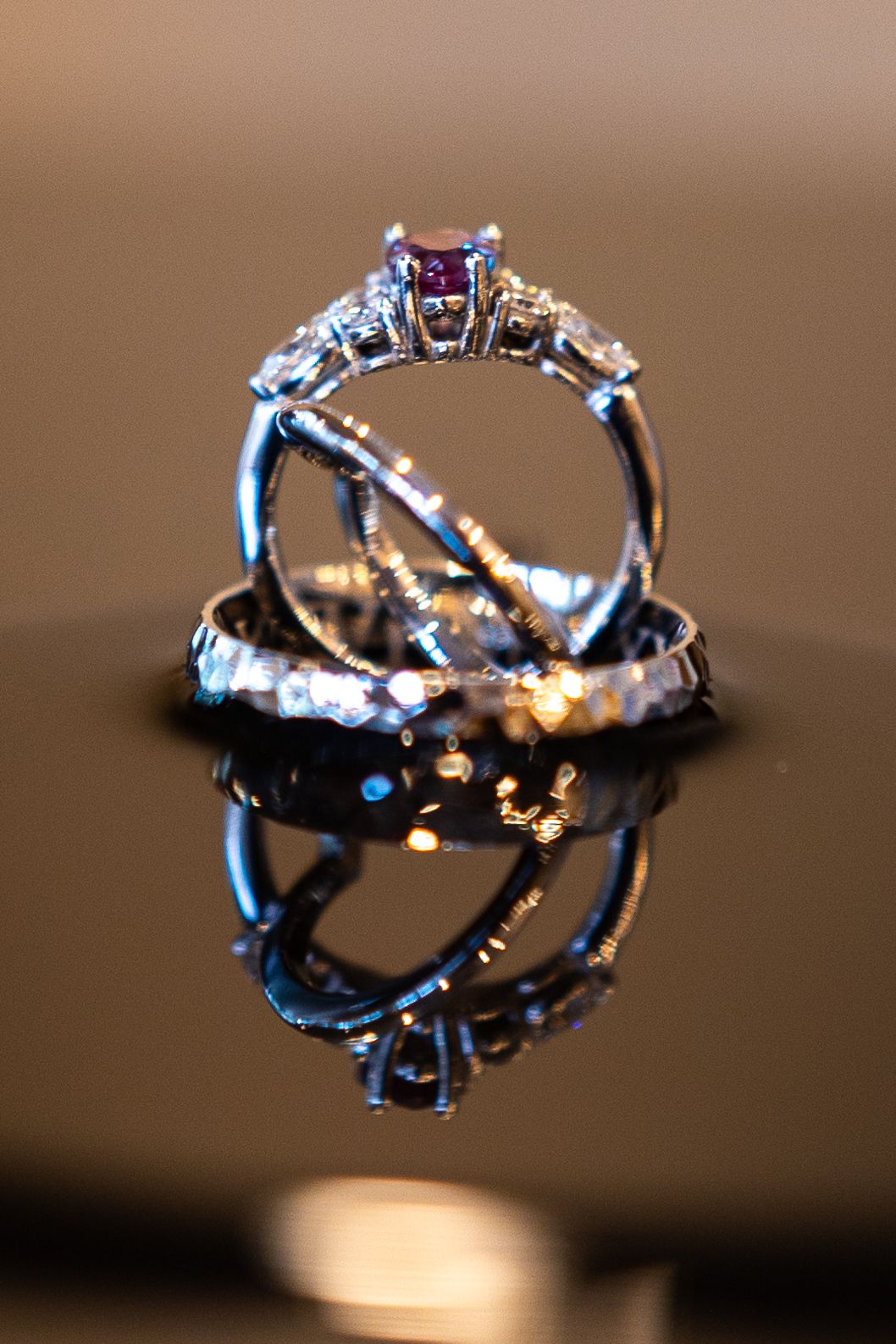 Macro shots of sparkling wedding rings with intricate details on dark background.