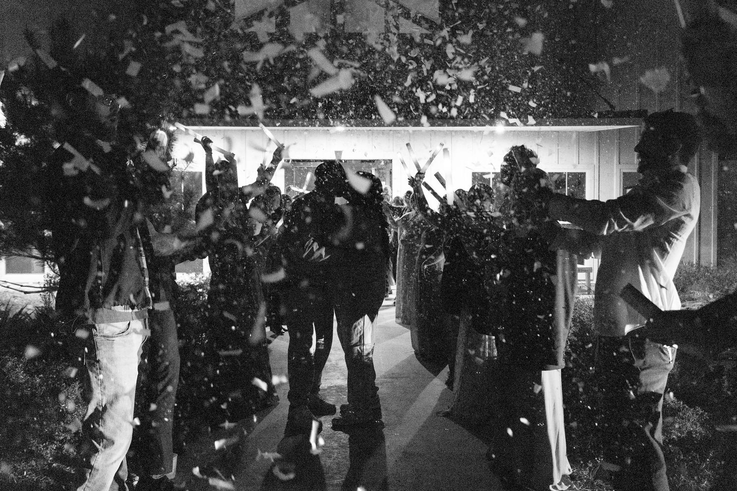 Black and white photo of a lively wedding reception dance floor.