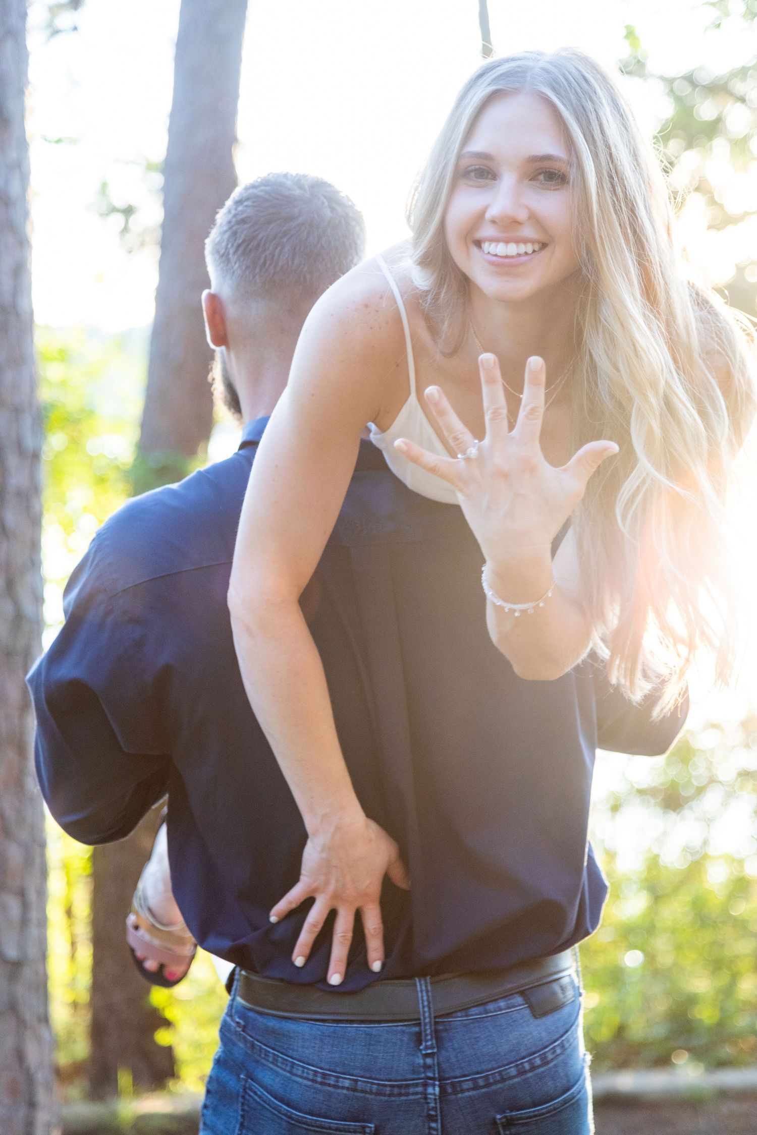 Playful sequence of poses showing someone in a navy top and jeans making expressive hand gestures outdoors.