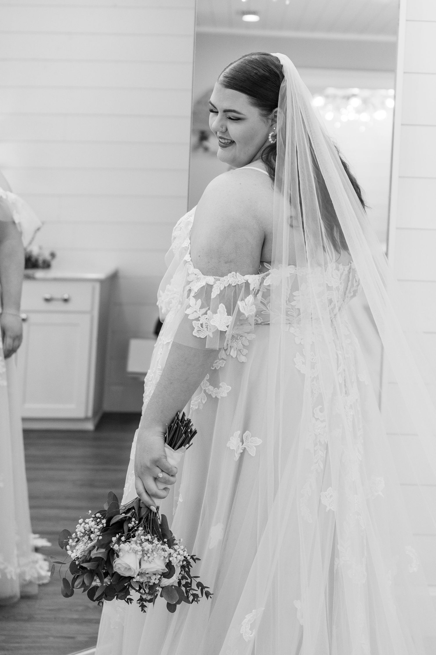 Flowing white wedding dress with lace details and long veil.