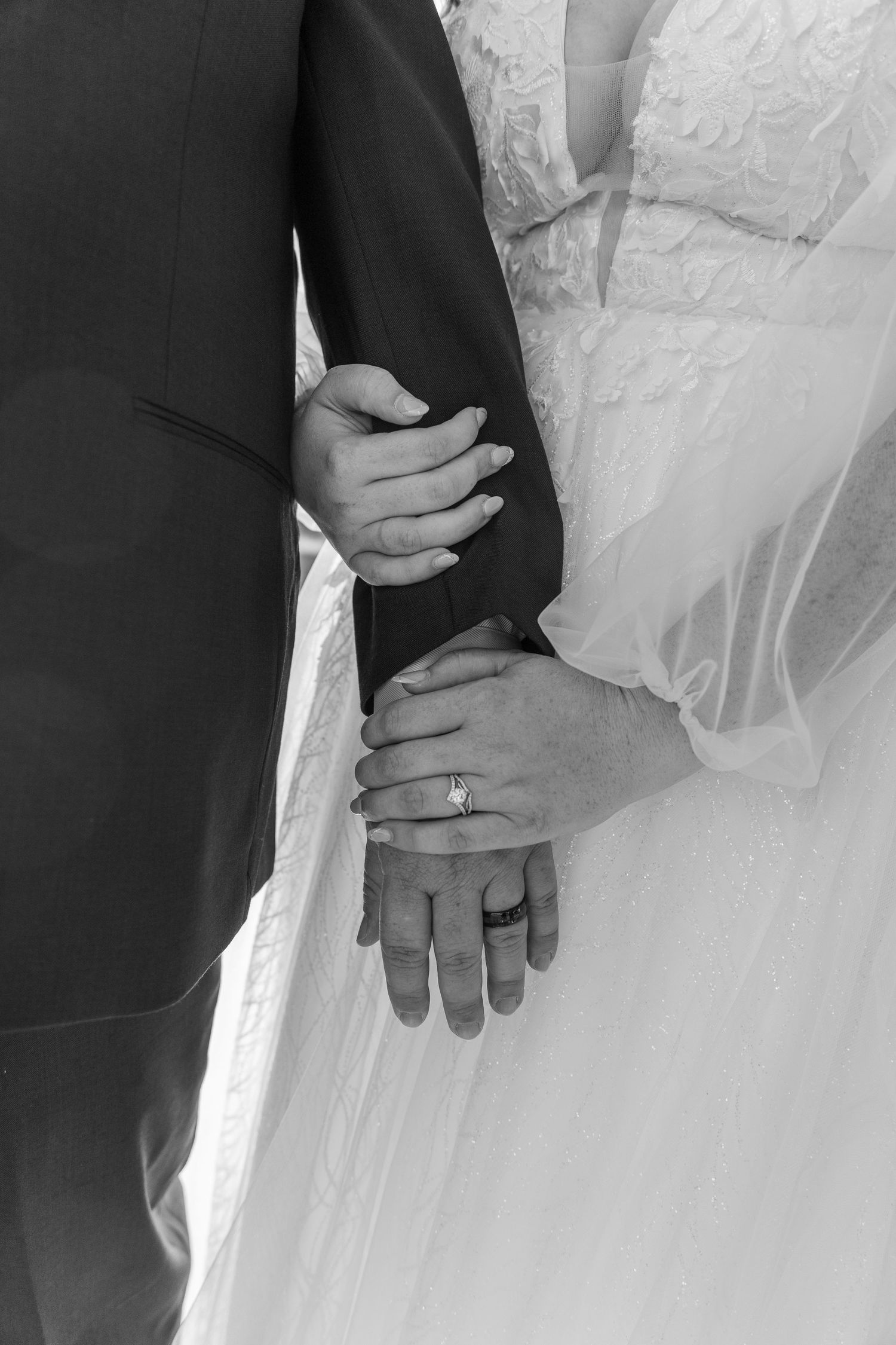 Detail shots of newlyweds holding hands showing wedding rings and formal attire.