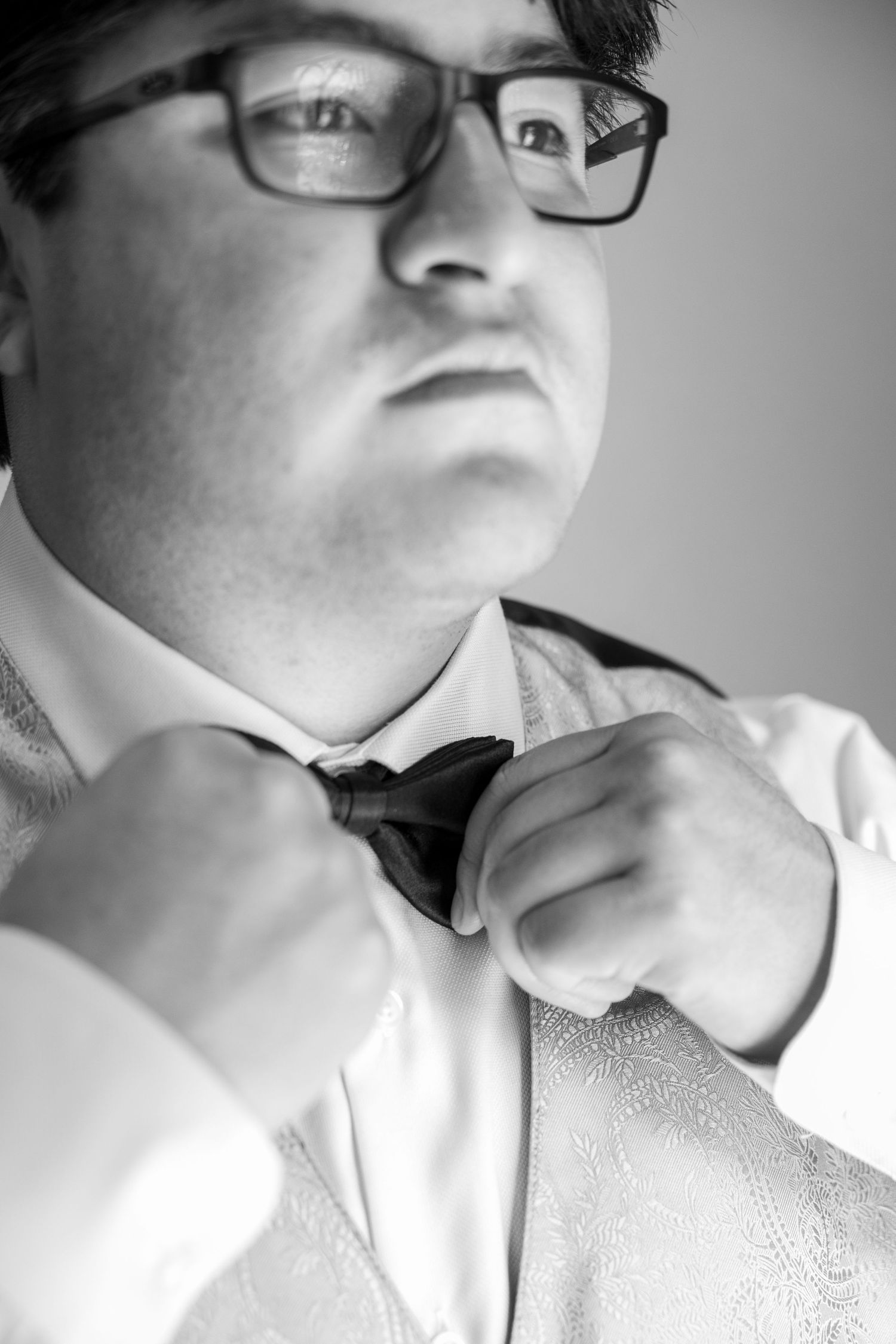 Close-up black and white photos showing details of formal attire and bow tie adjustments.