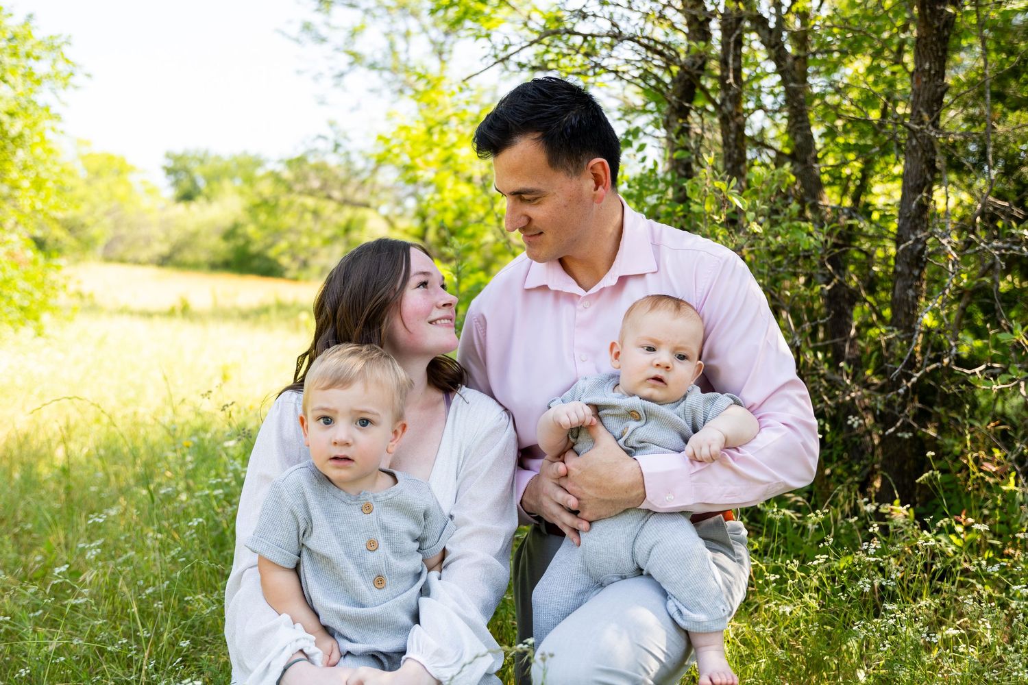 Family portrait sequence in sunny meadow with small children and natural lighting.