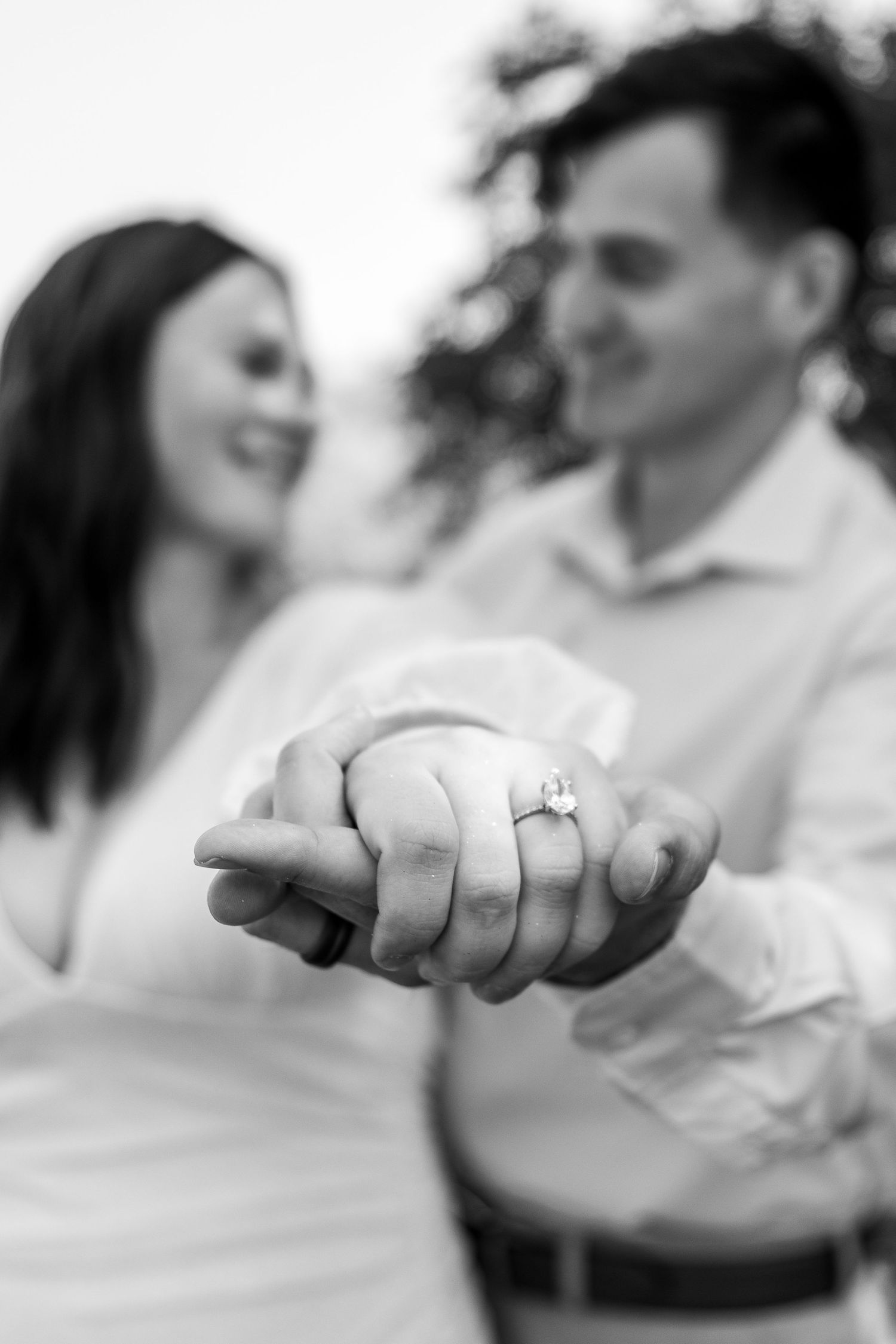 Black and white series of hands intertwined showing intimate connection and engagement ring.