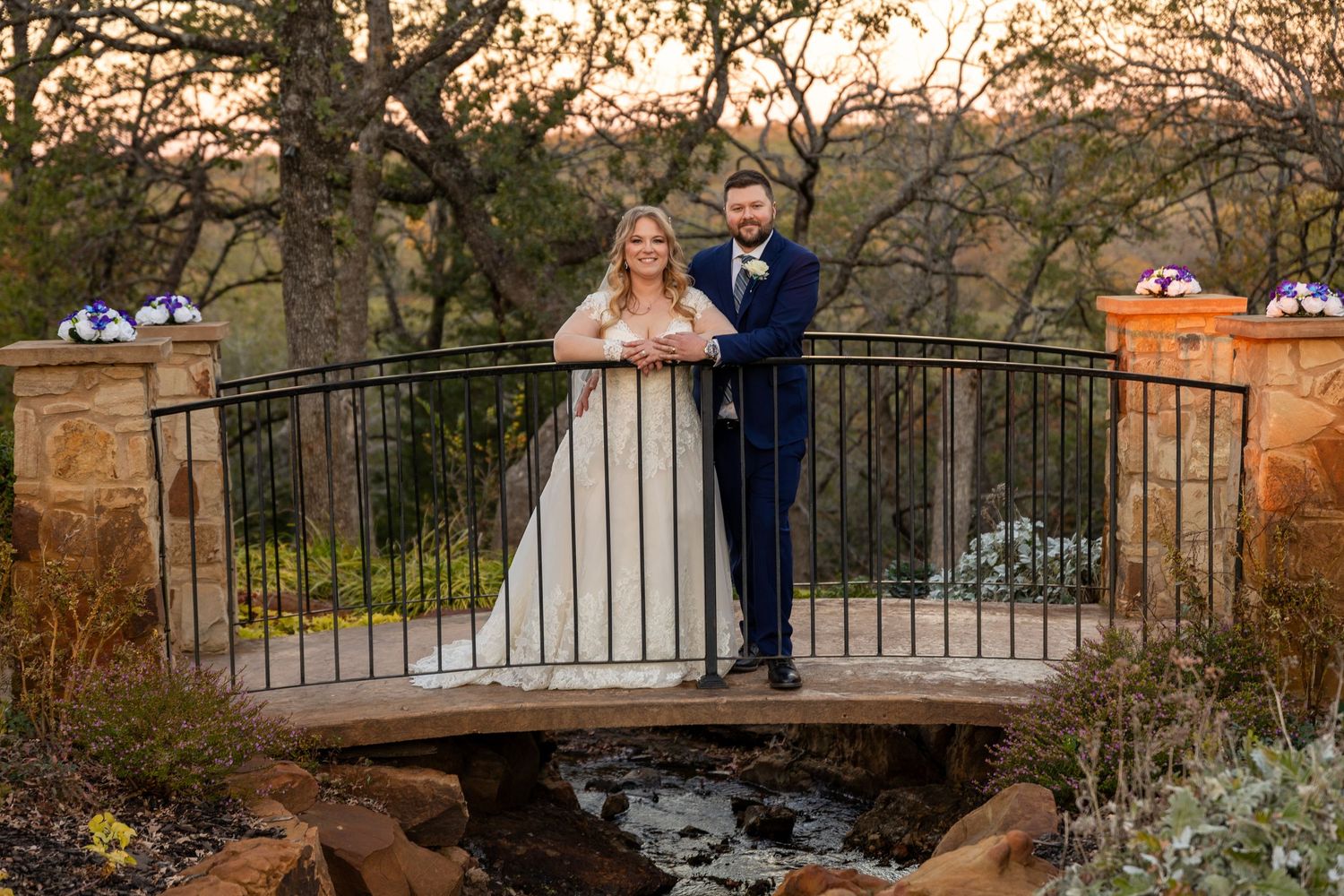 A romantic wedding photo series on a rustic bridge at sunset with elegant white decorations.
