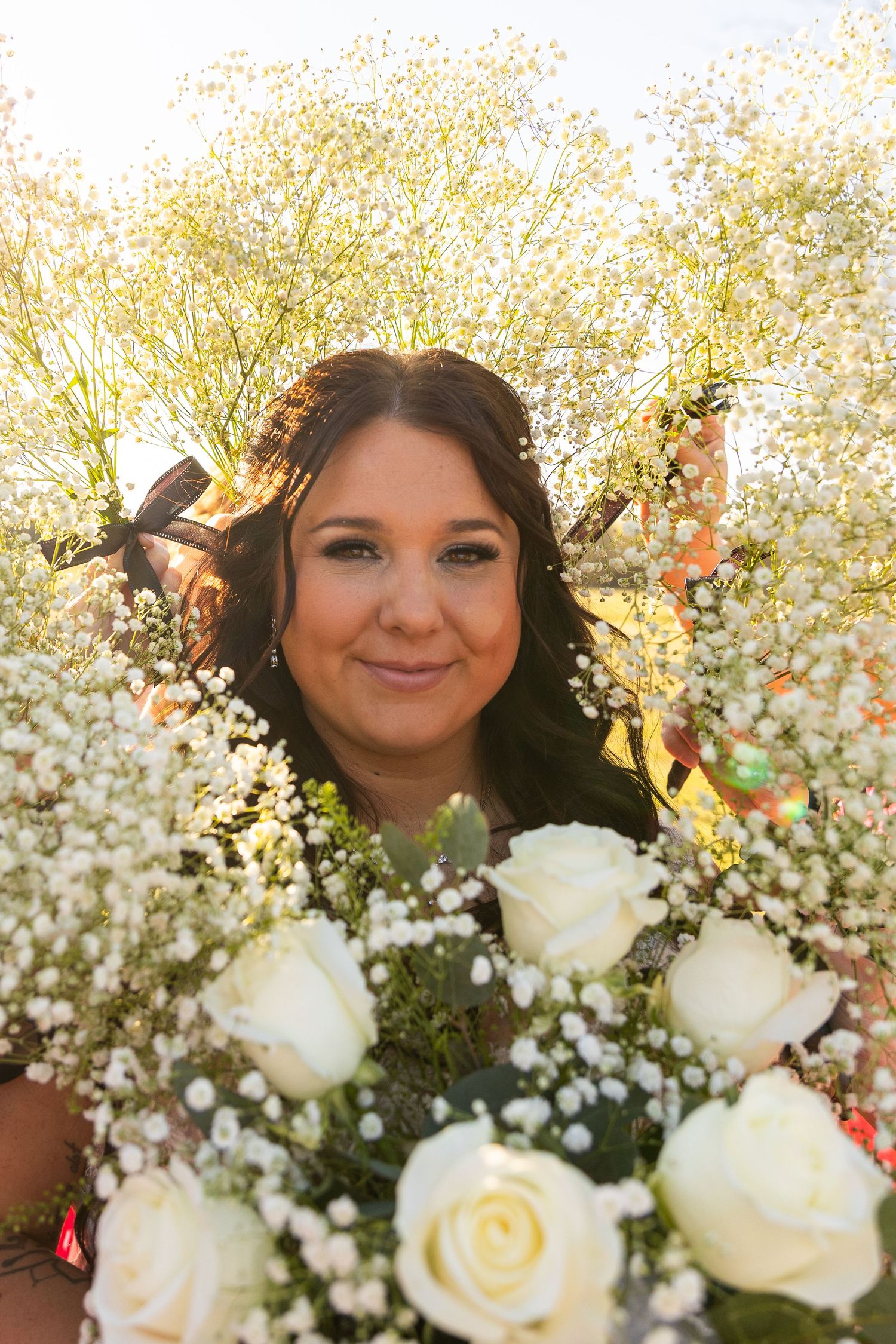 White roses and baby's breath bouquet with golden sunlight filtering through.