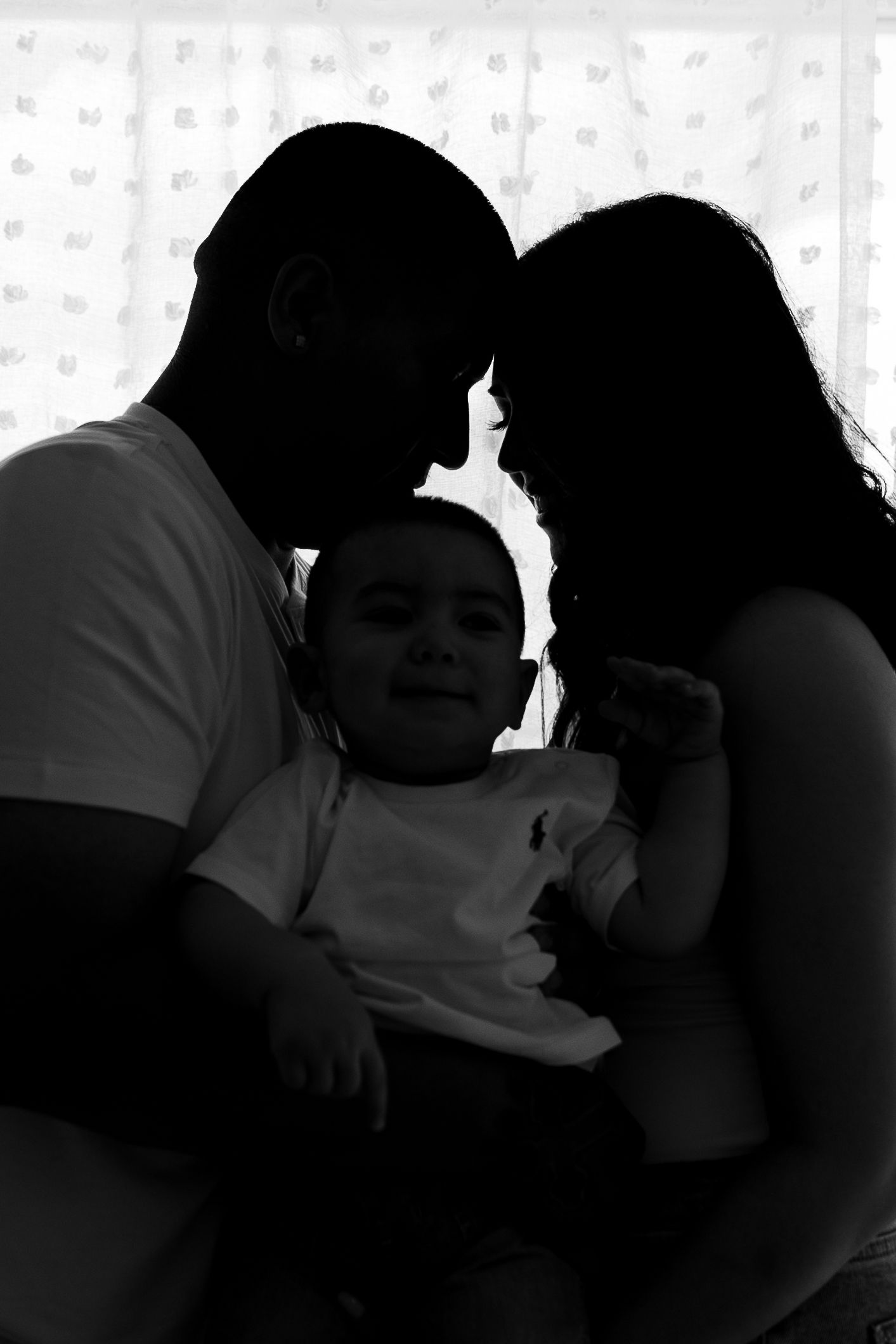 Silhouette series capturing intimate family moments against textured background.