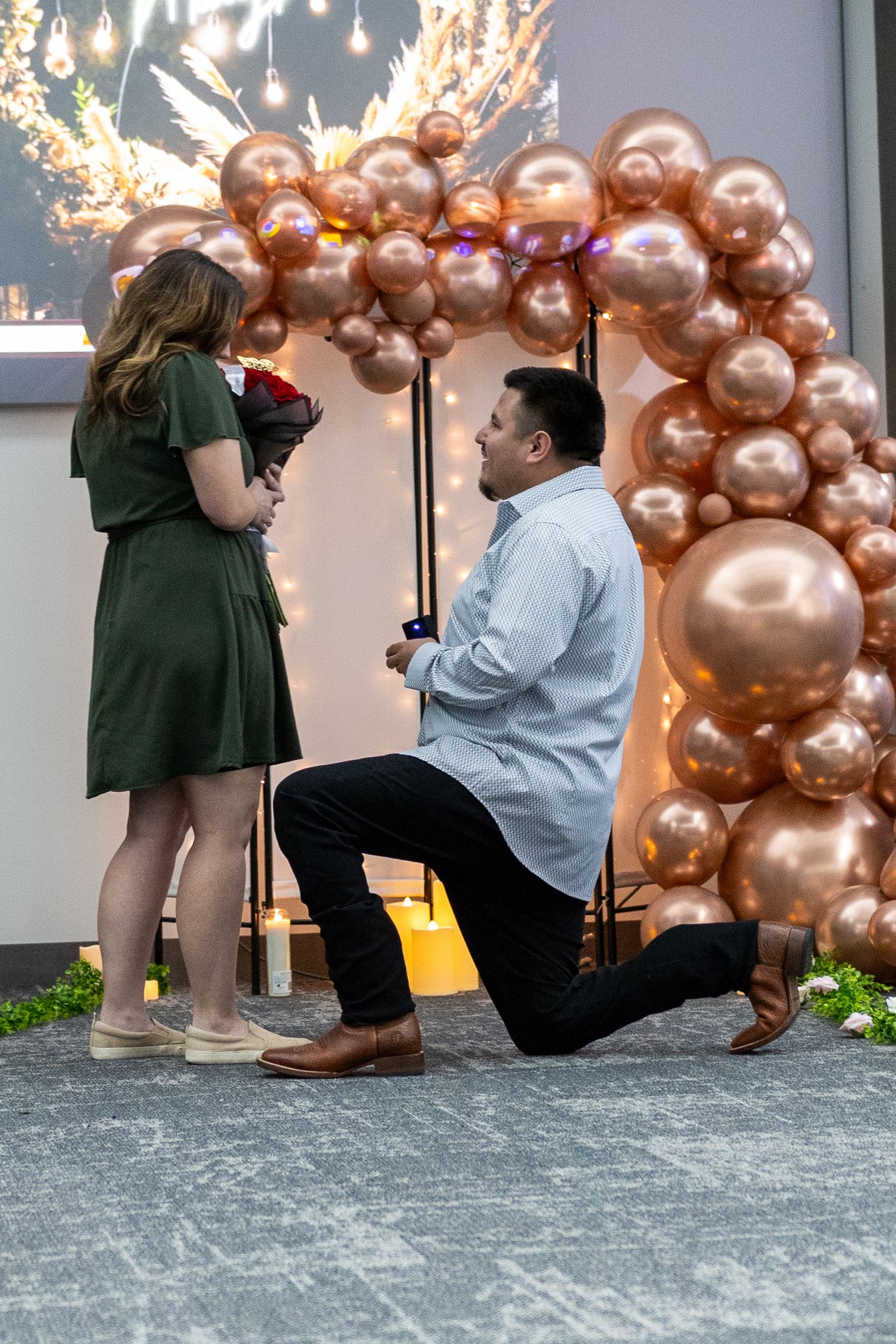 A proposal sequence with rose gold balloon arch decorations and romantic lighting.