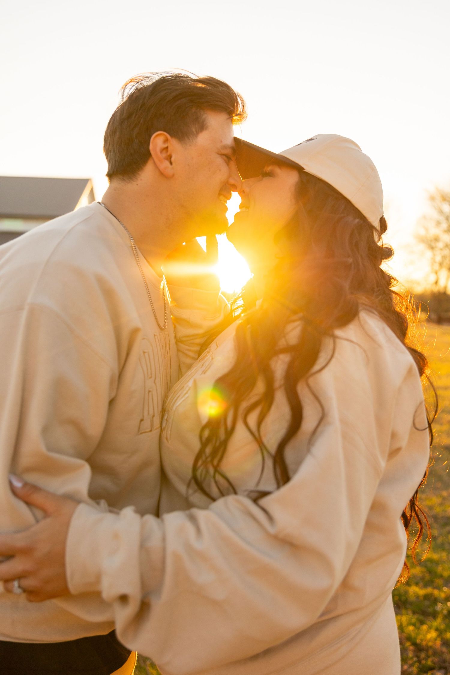 Romantic sunset moment captured in warm golden light with soft silhouettes.