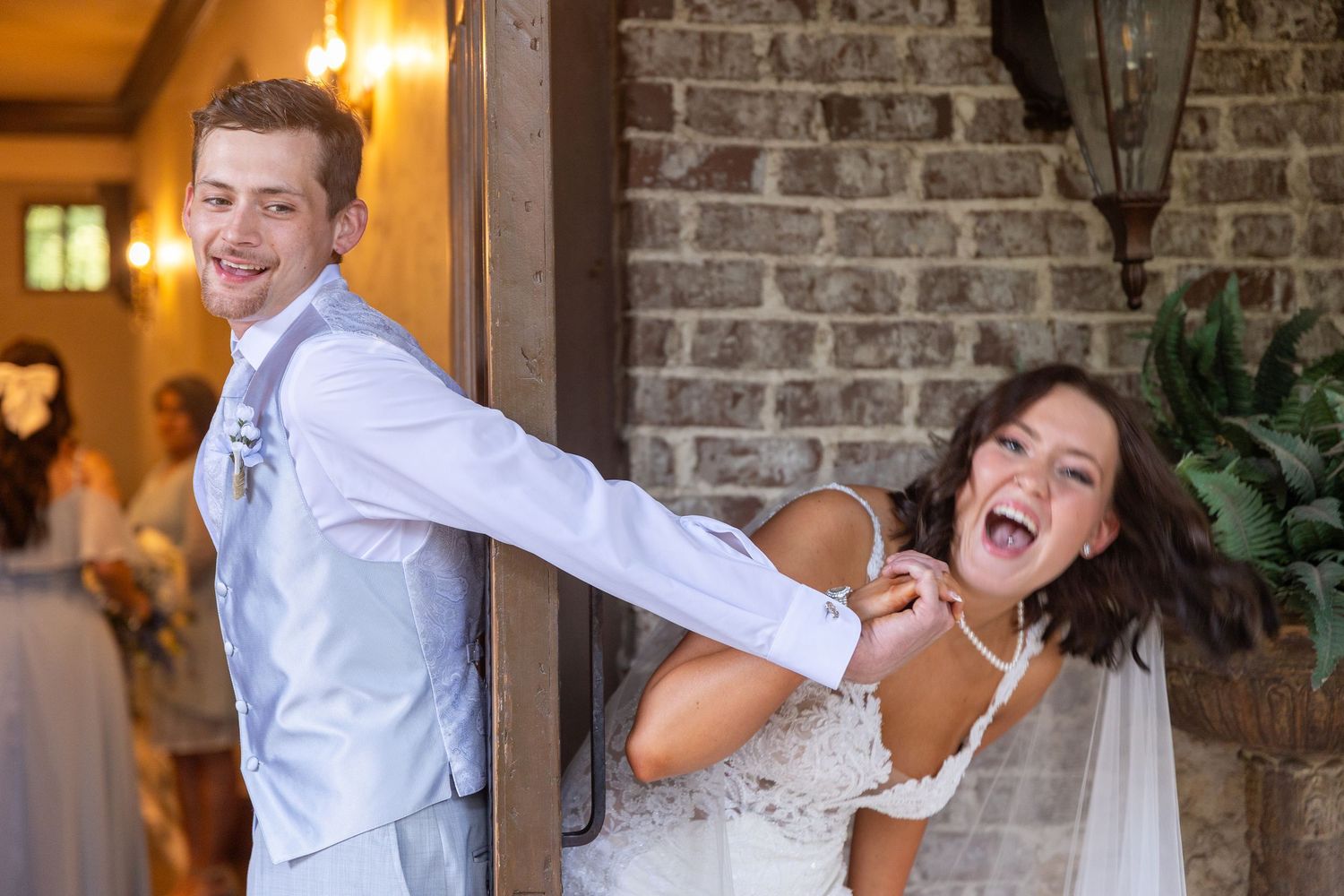 Candid wedding photos showing joyful dance moves in front of a stone wall.