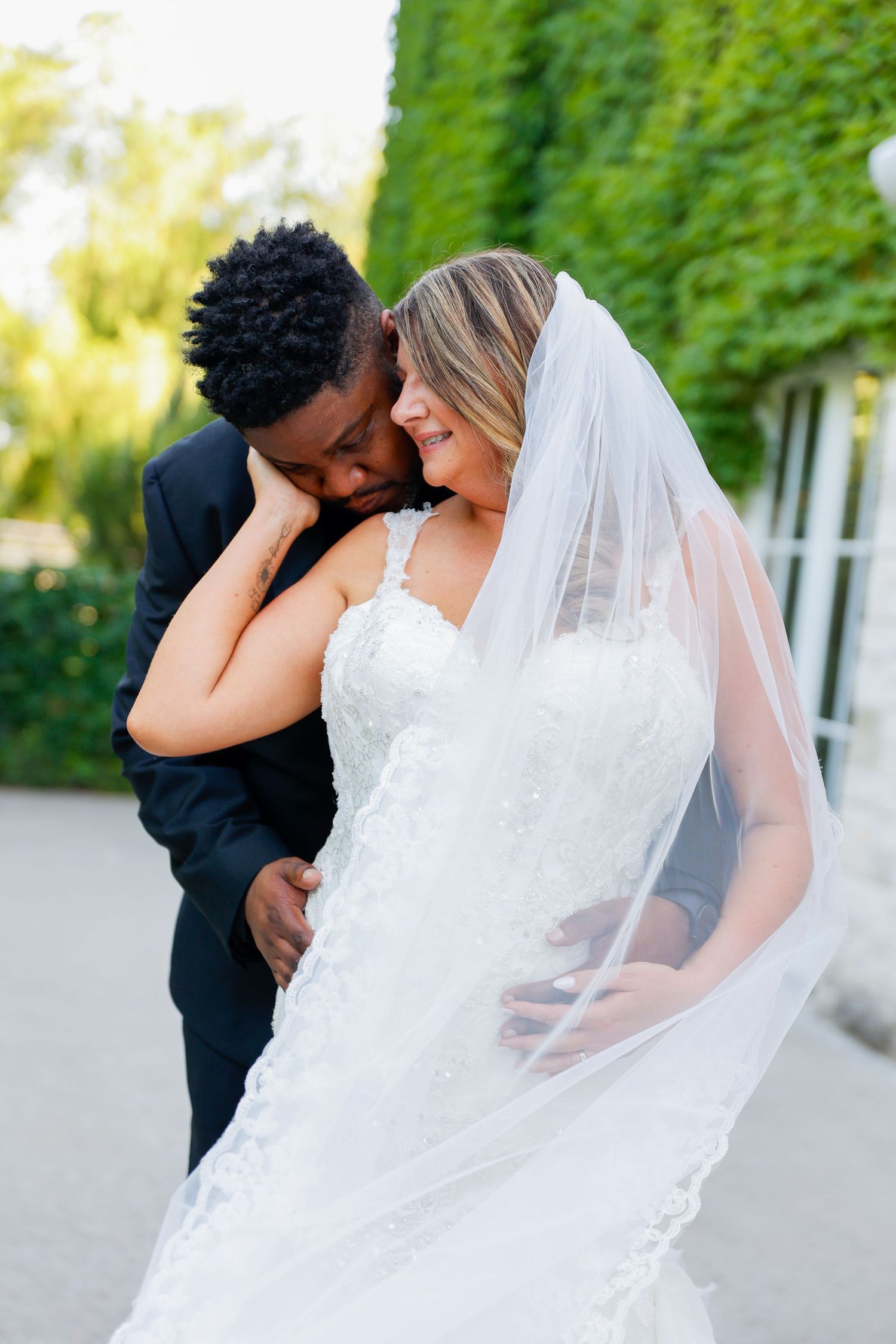 Romantic wedding portraits captured against an ivy-covered wall at sunset.