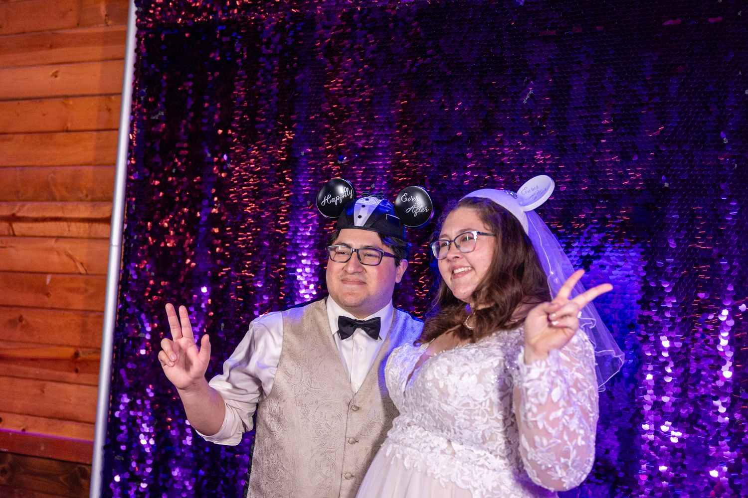 Wedding celebration with purple sparkly backdrop and festive party atmosphere.
