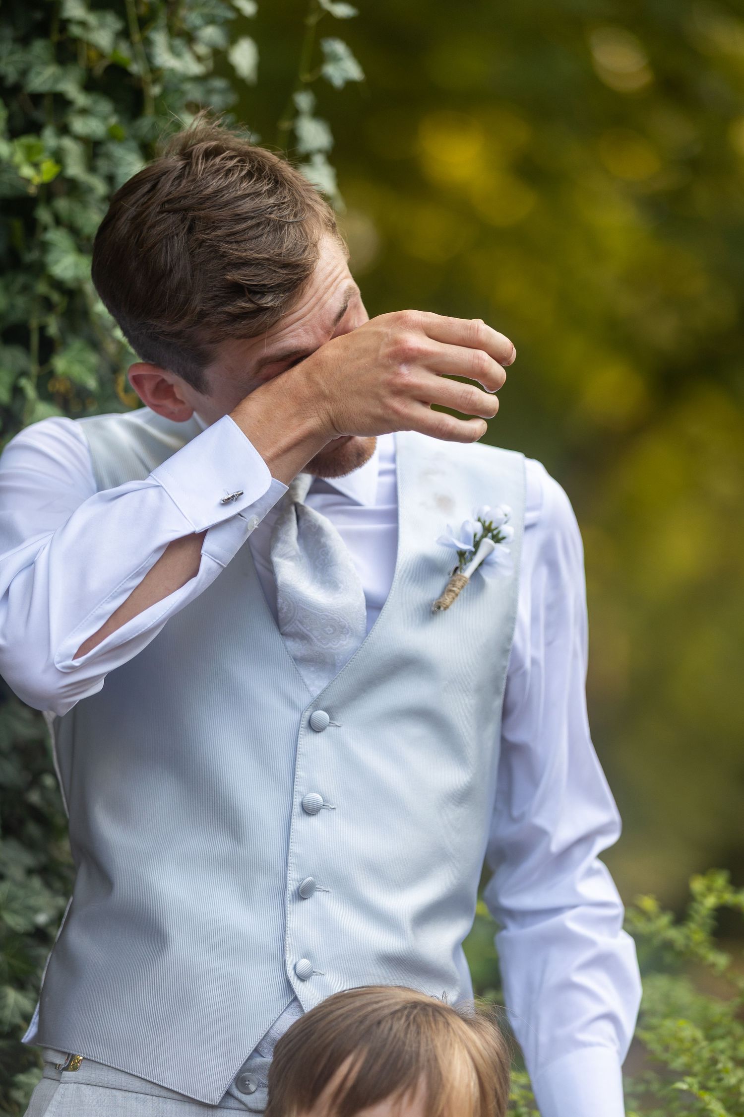 Emotional wedding moment captured in an outdoor garden setting.