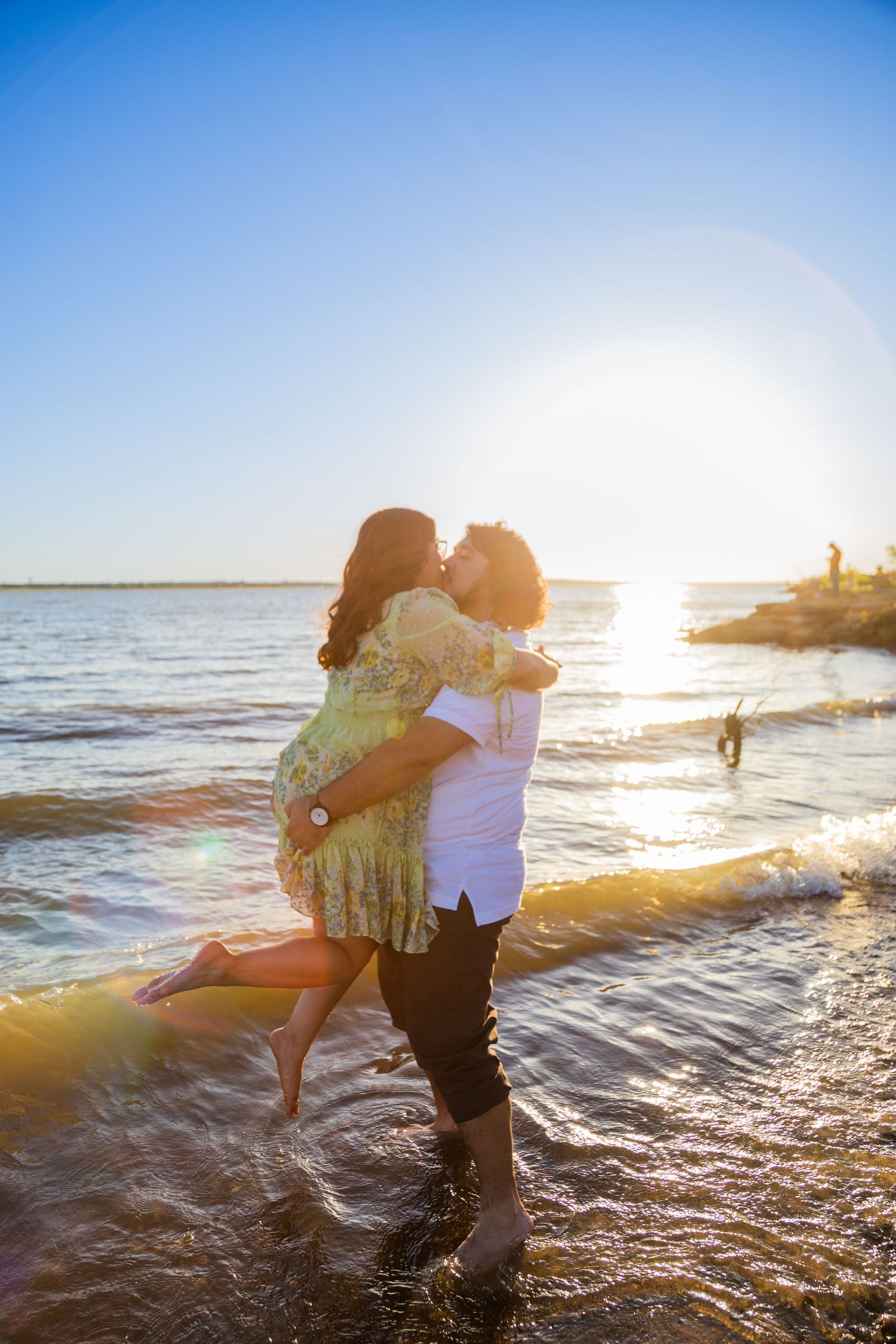 Couple shares romantic moment at beach during golden hour sunset.