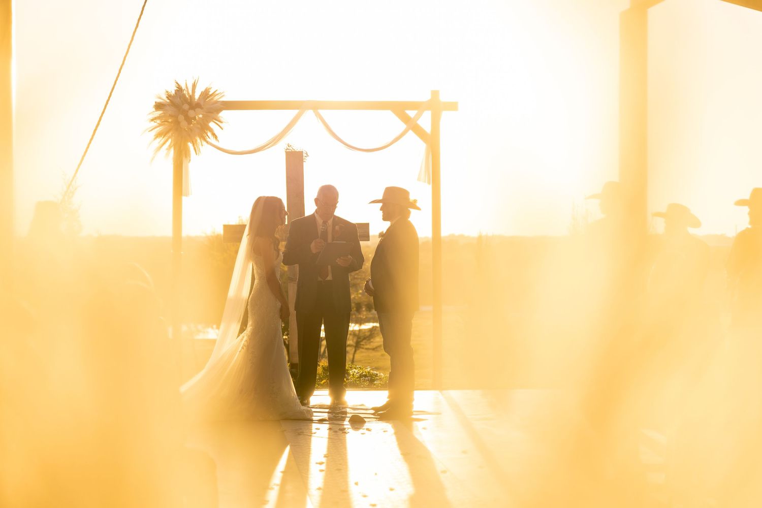 Silhouettes of people against warm sunset lighting through large windows.