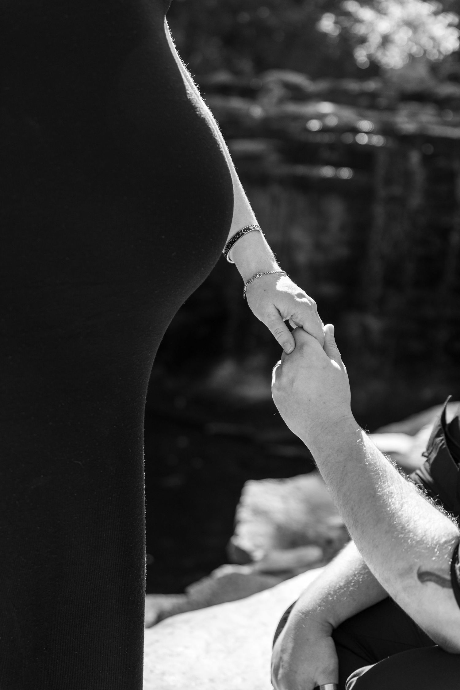 Close-up black and white photos showing hands cradling a pregnant belly.