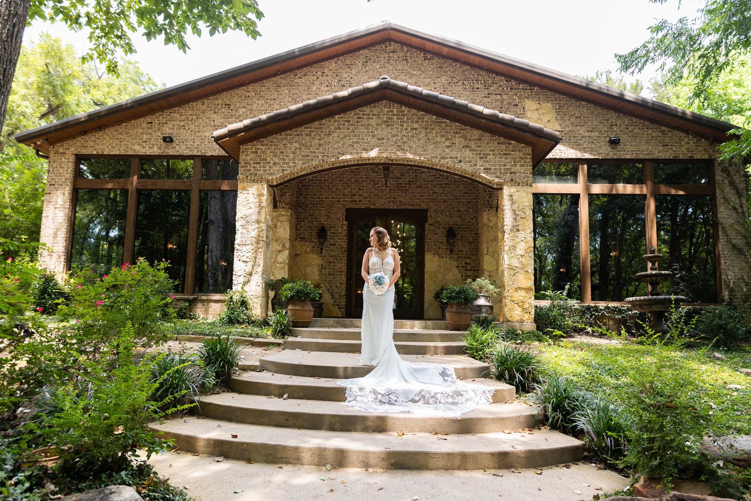 Stone chapel with elegant archways and fountain creates romantic wedding venue setting.