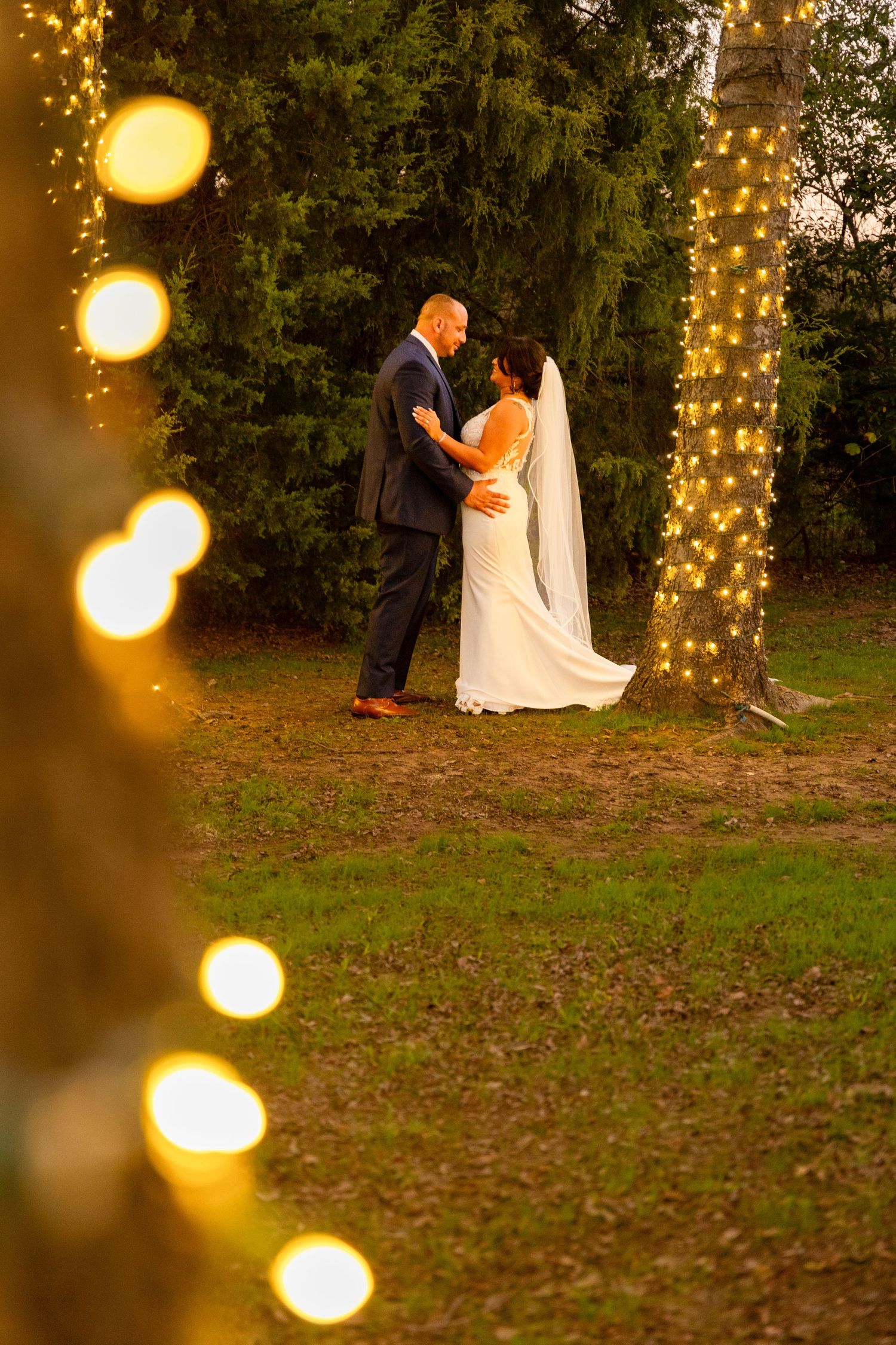 Wedding photos with fairy lights creating bokeh effects in an outdoor evening setting.