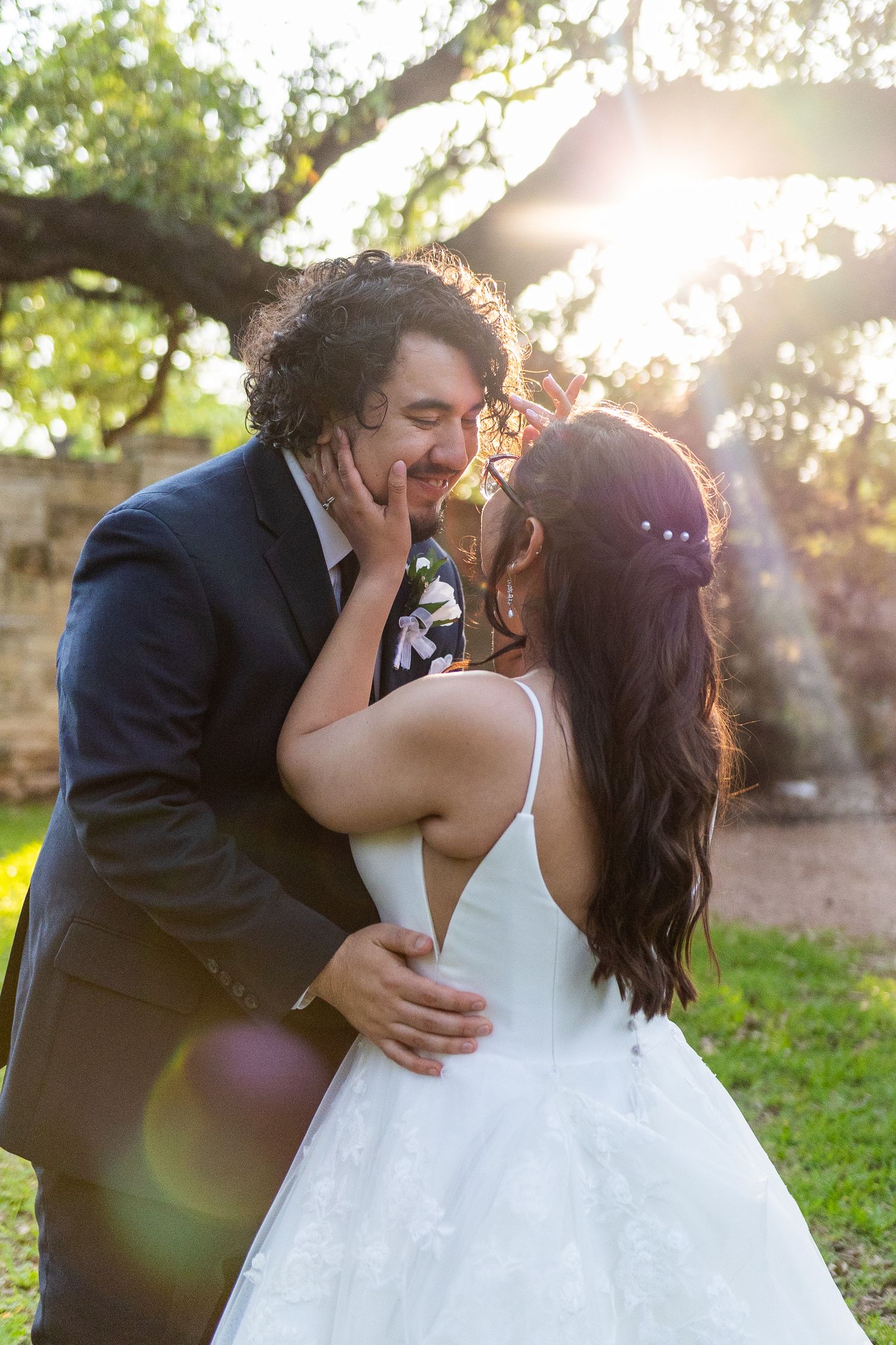 A romantic sunset moment between newlyweds in a garden with beautiful lens flare.