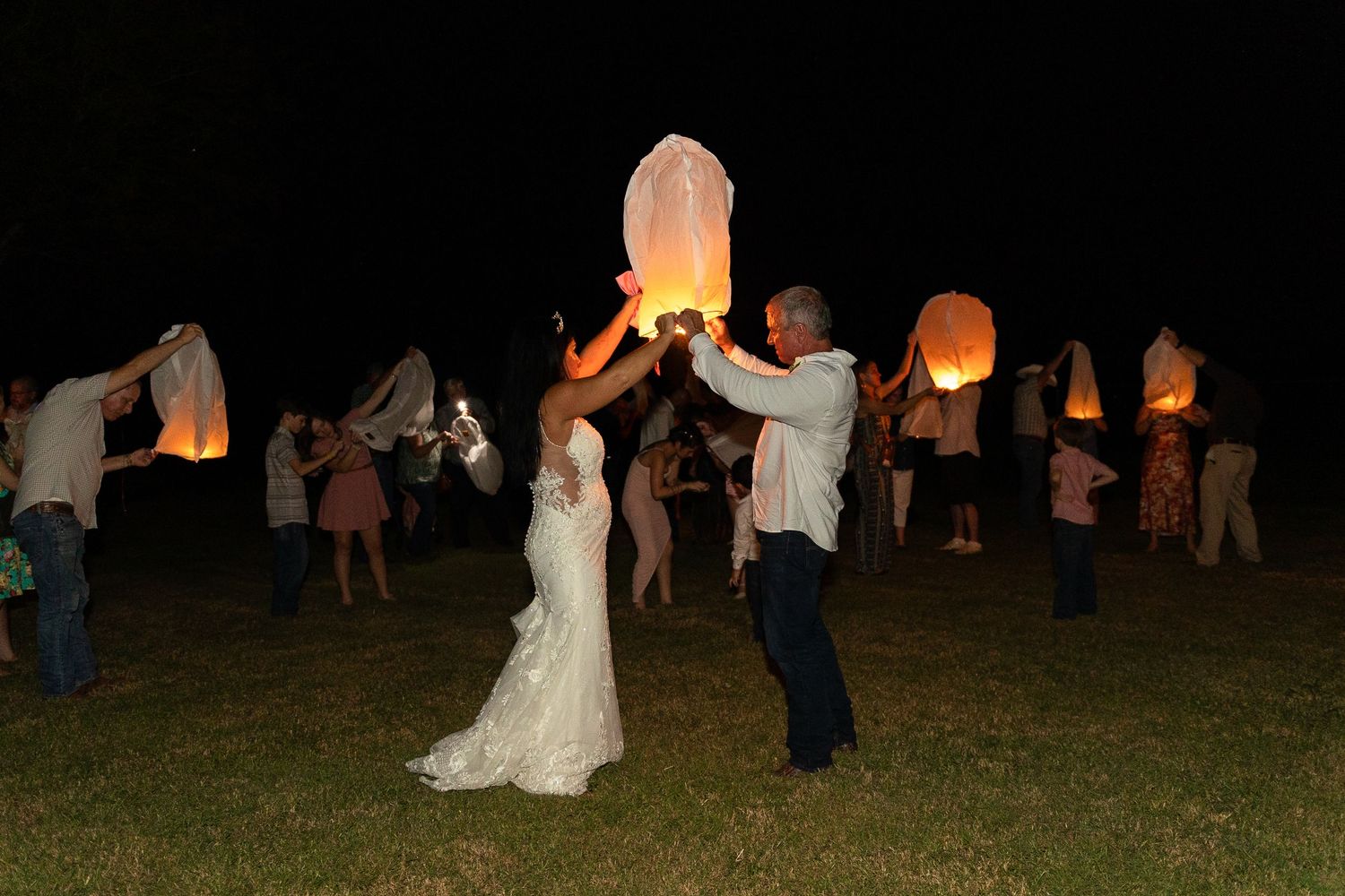 Wedding reception celebration at night with lanterns glowing in the darkness.