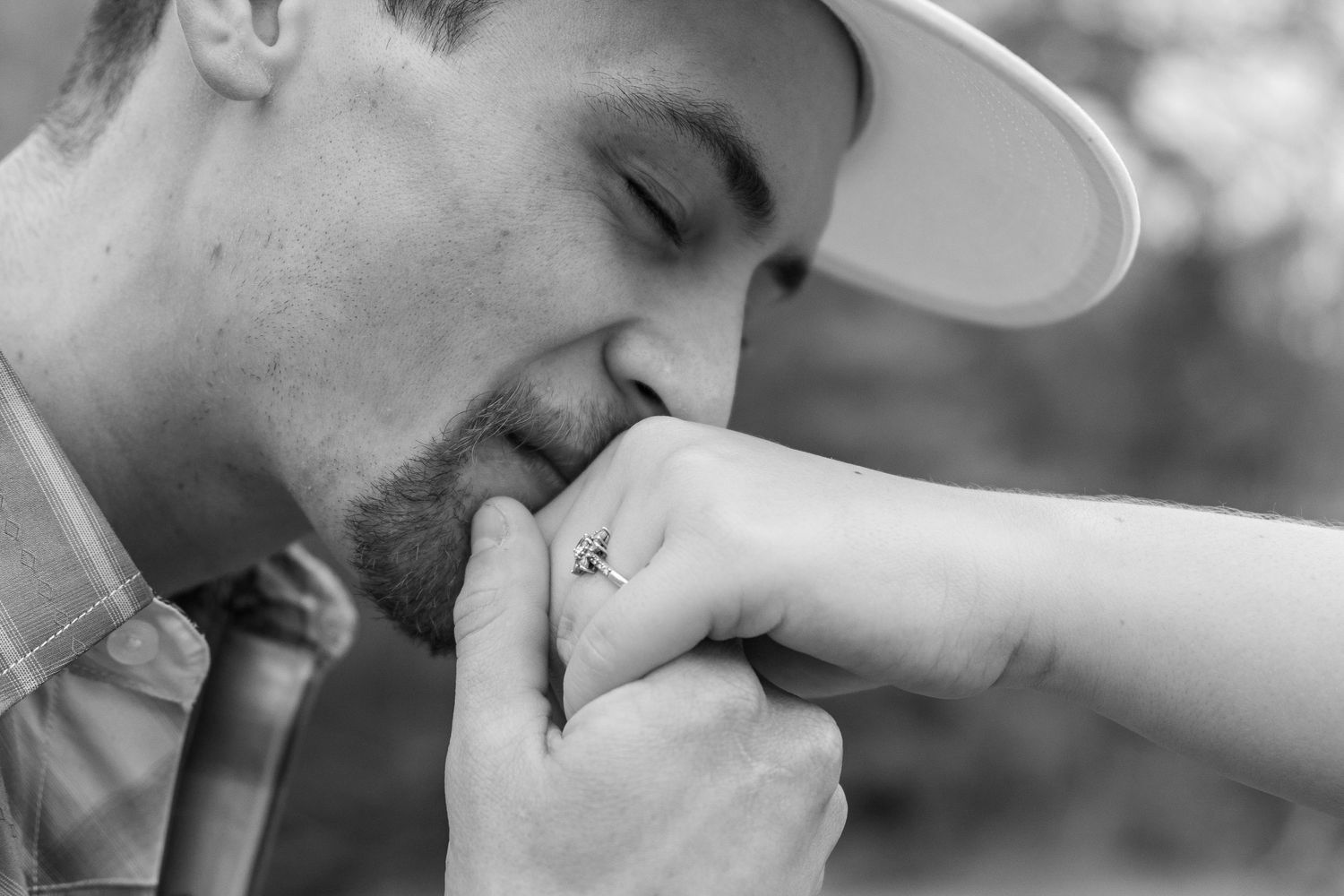 An intimate black and white moment showing a gentle hand kiss.