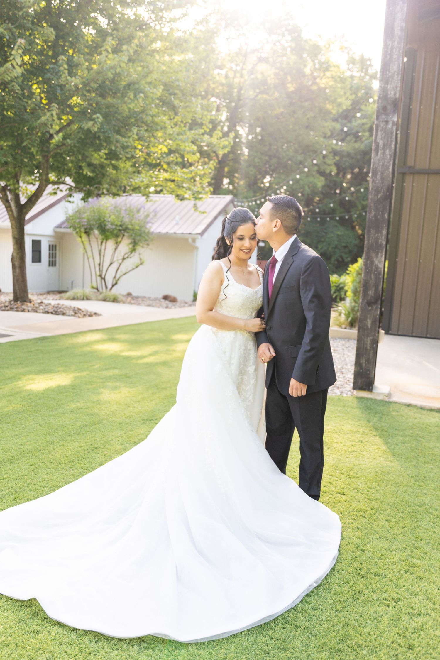 Romantic wedding portraits in sunlit garden with flowing white dress.