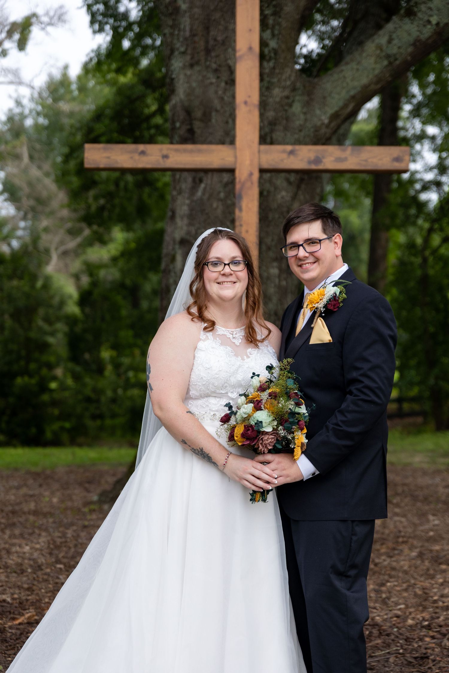 Newlyweds sharing a joyful moment together outdoors with autumn-colored bouquet.
