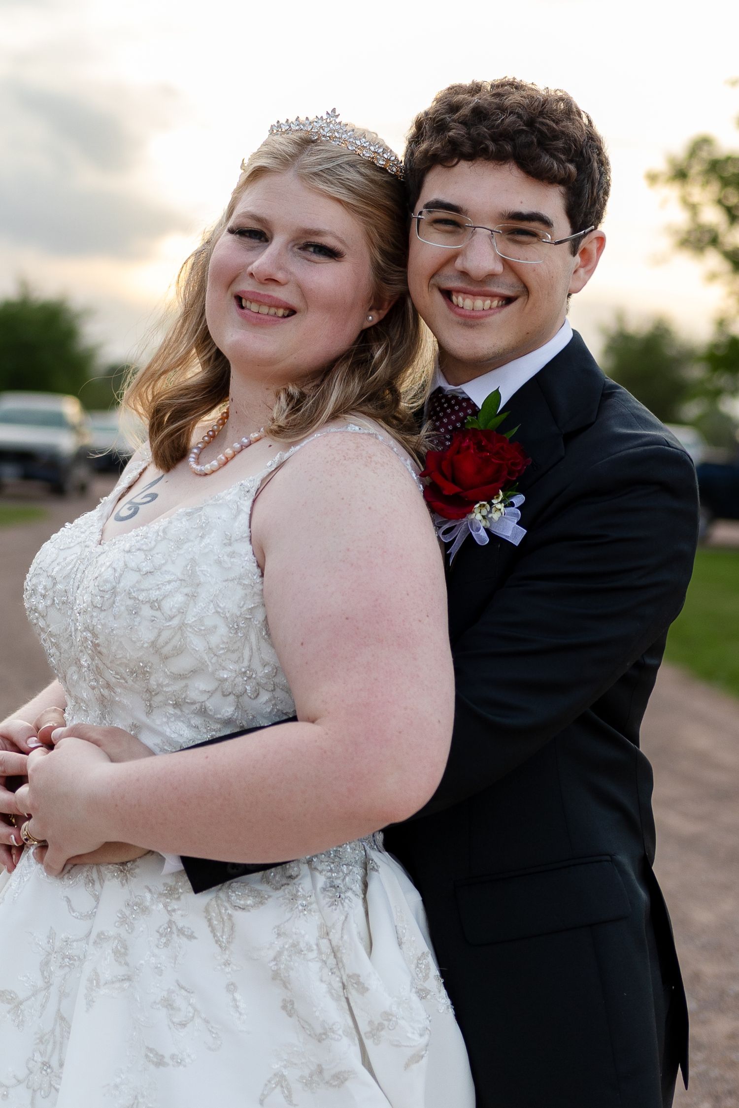 Joyful wedding couple posing outdoors during golden hour portraits.