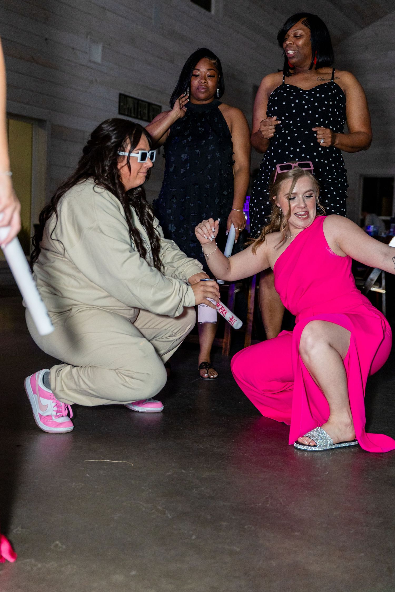 Energetic dance moves on the reception floor with guests in pink and beige outfits.