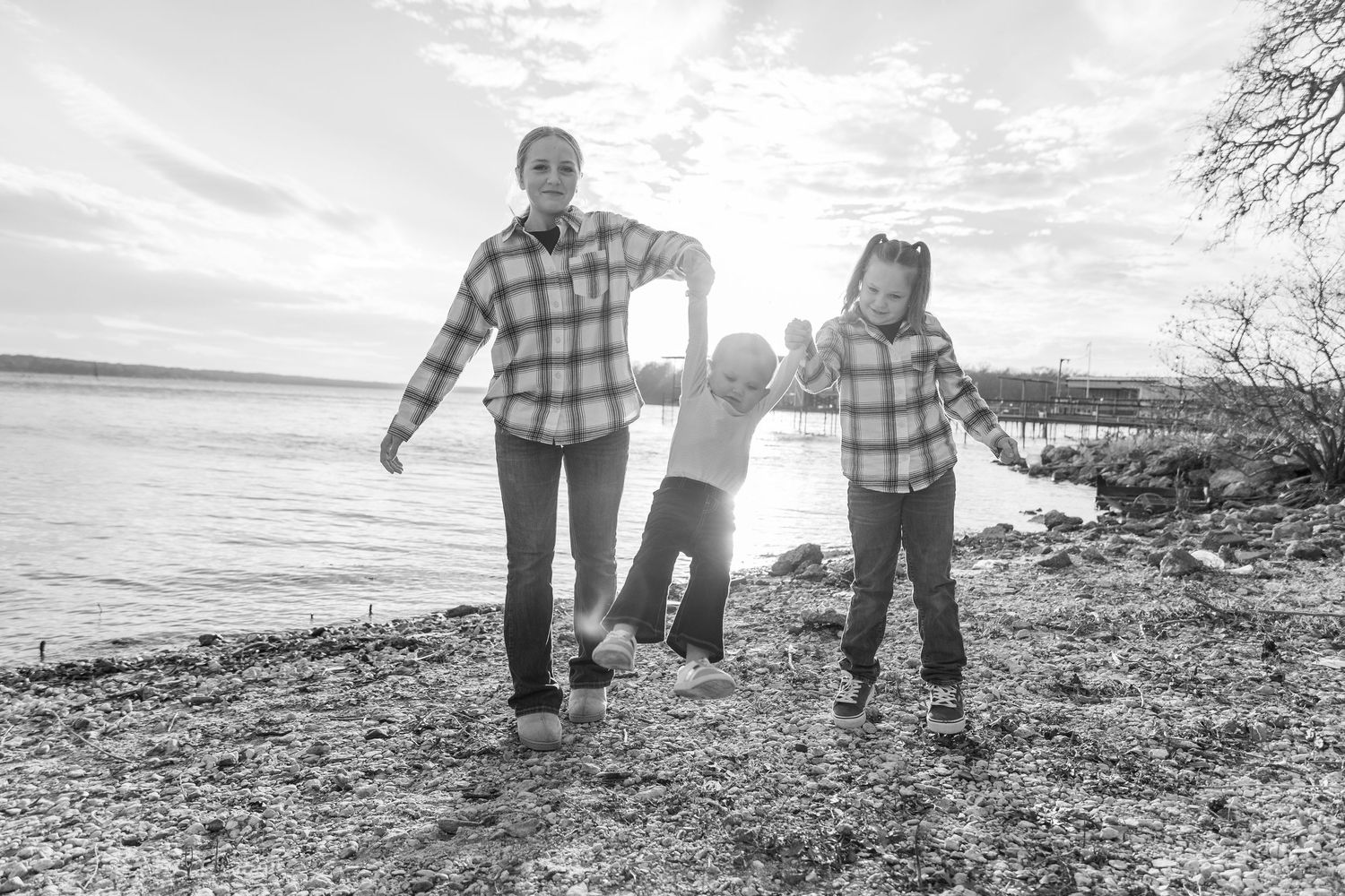Black and white panoramic series of people walking along a shoreline at sunset.