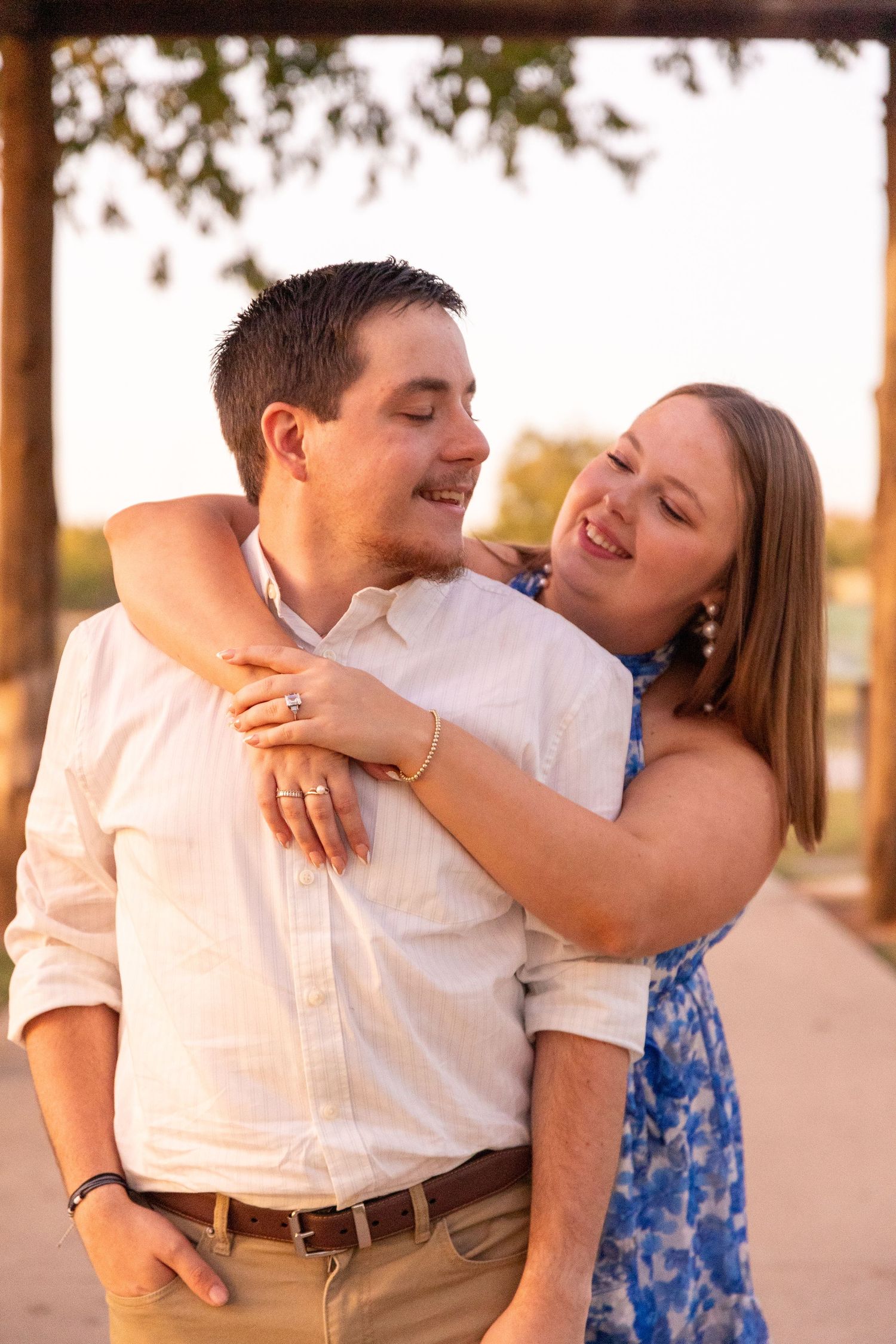 Romantic couple sharing tender moments during golden hour under a covered walkway.