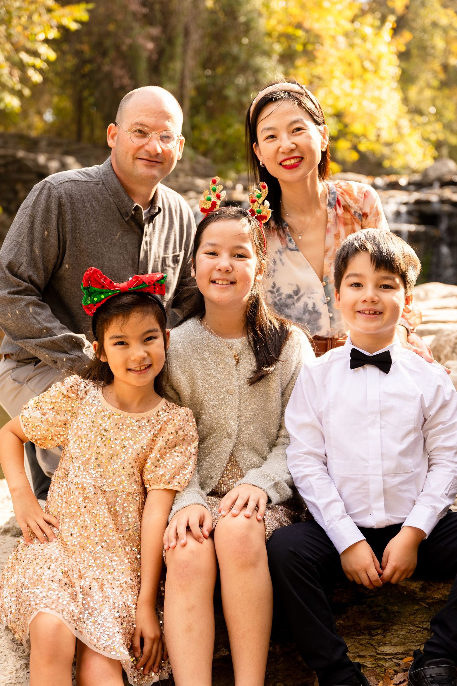 Group sitting together on stone steps during autumn with warm lighting and fall foliage.